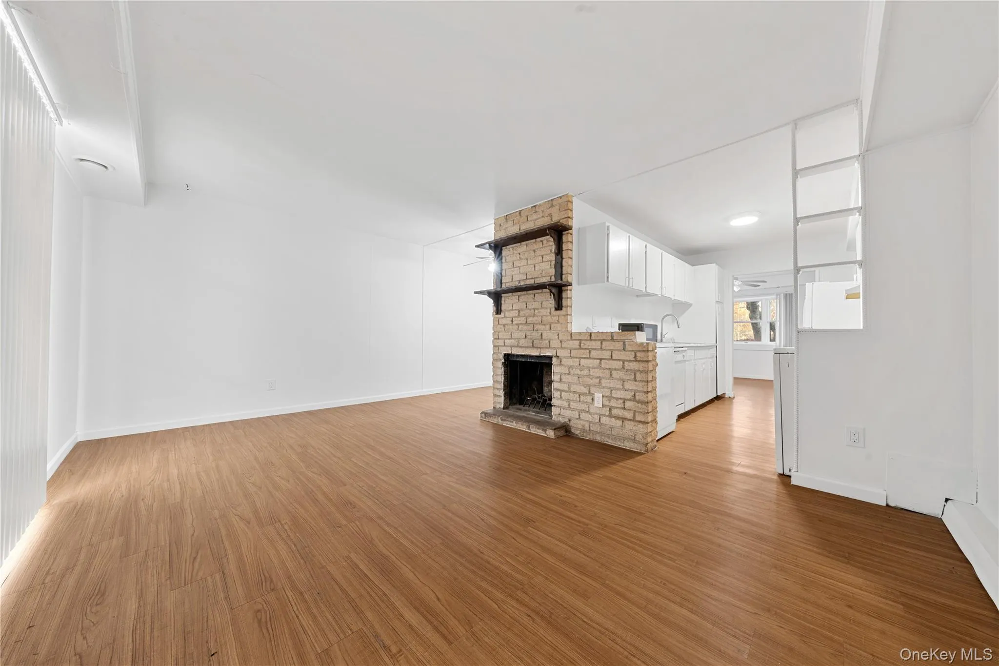 Unfurnished living room with light wood-style floors and a fireplace Unfurnished living room with light wood-style floors and a fireplace
