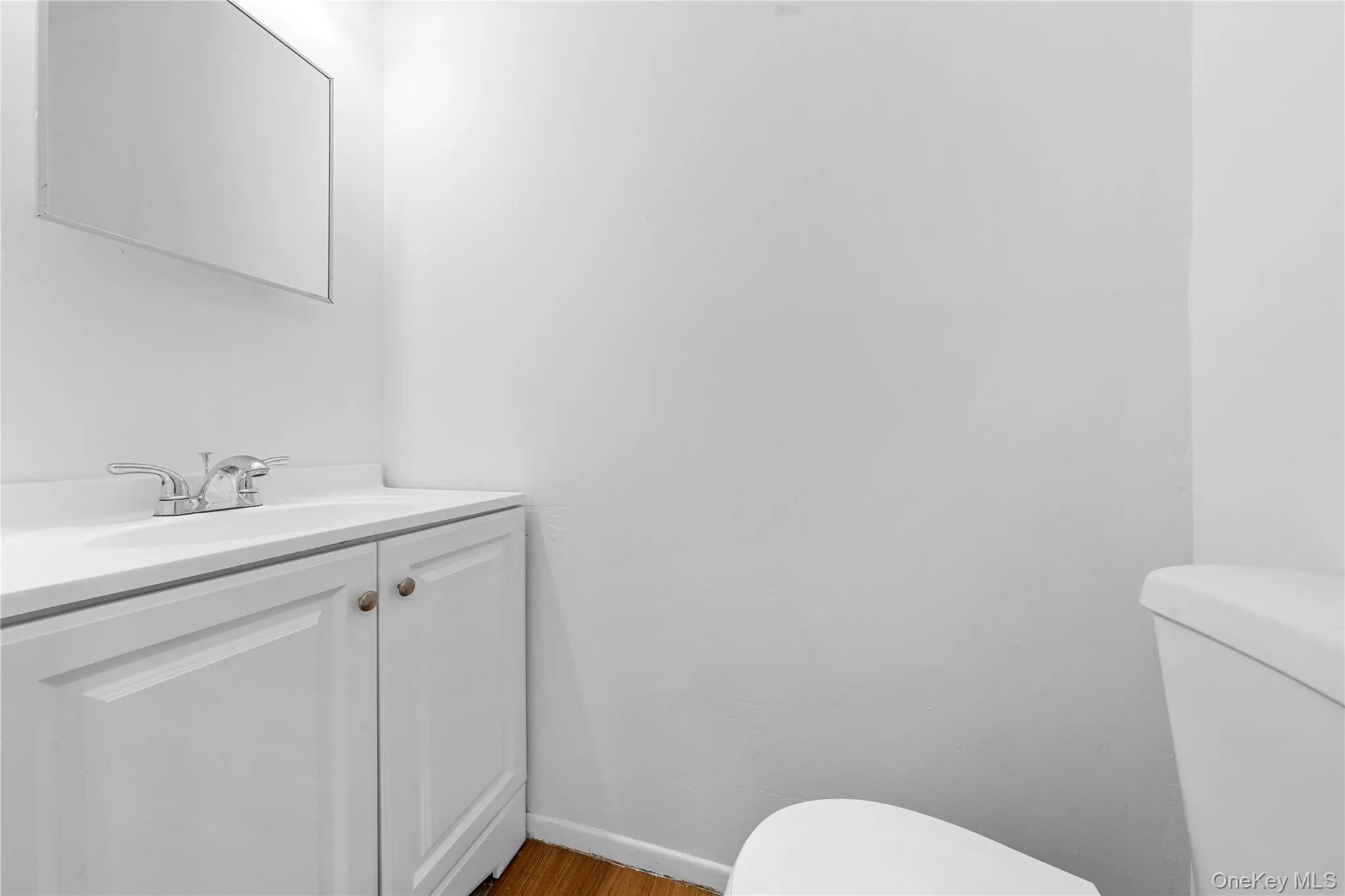Half bathroom with vanity and wood finished floors Half bathroom with vanity and wood finished floors