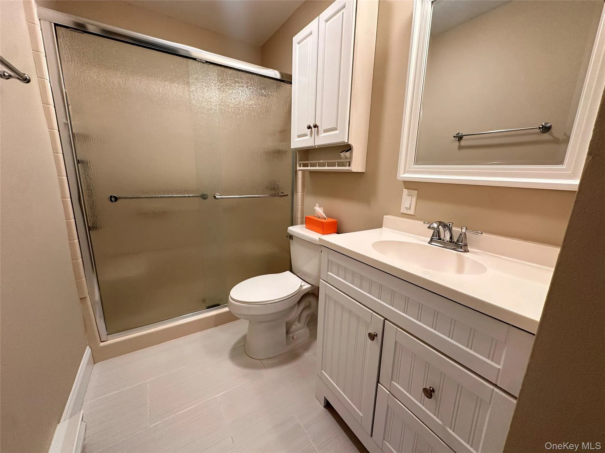 Full bath featuring vanity, a stall shower, and light tile patterned floors Full bath featuring vanity, a stall shower, and light tile patterned floors