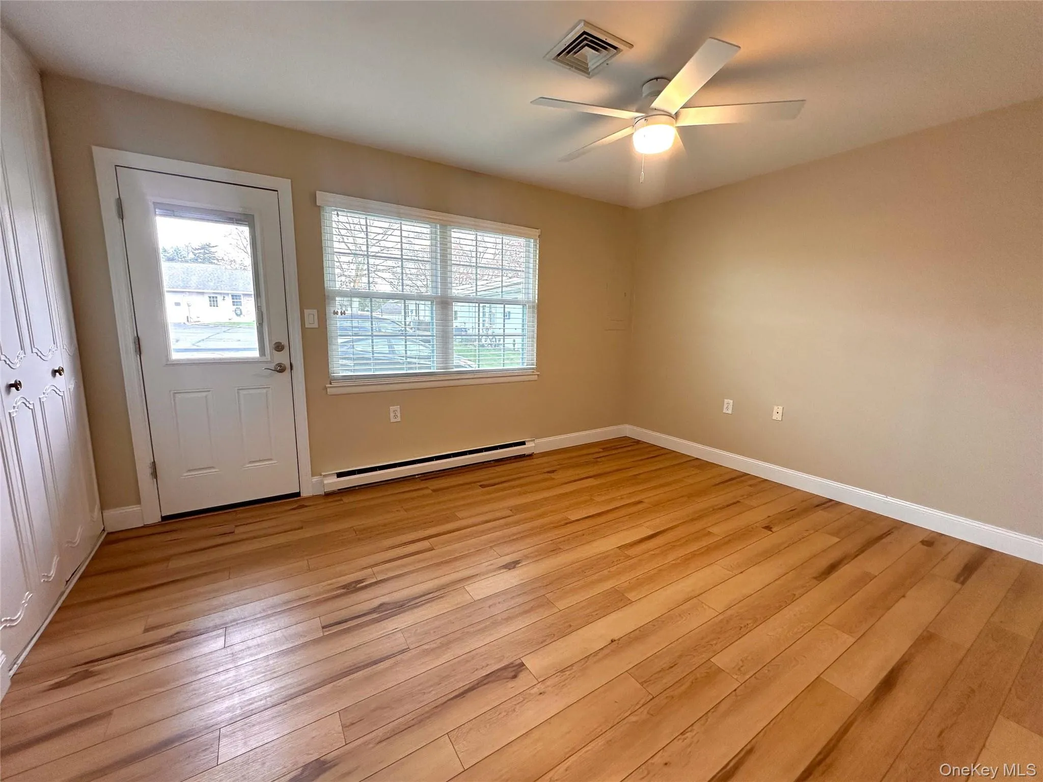 Unfurnished room featuring a baseboard radiator, light wood-type flooring, and ceiling fan Unfurnished room featuring a baseboard radiator, light wood-type flooring, and ceiling fan