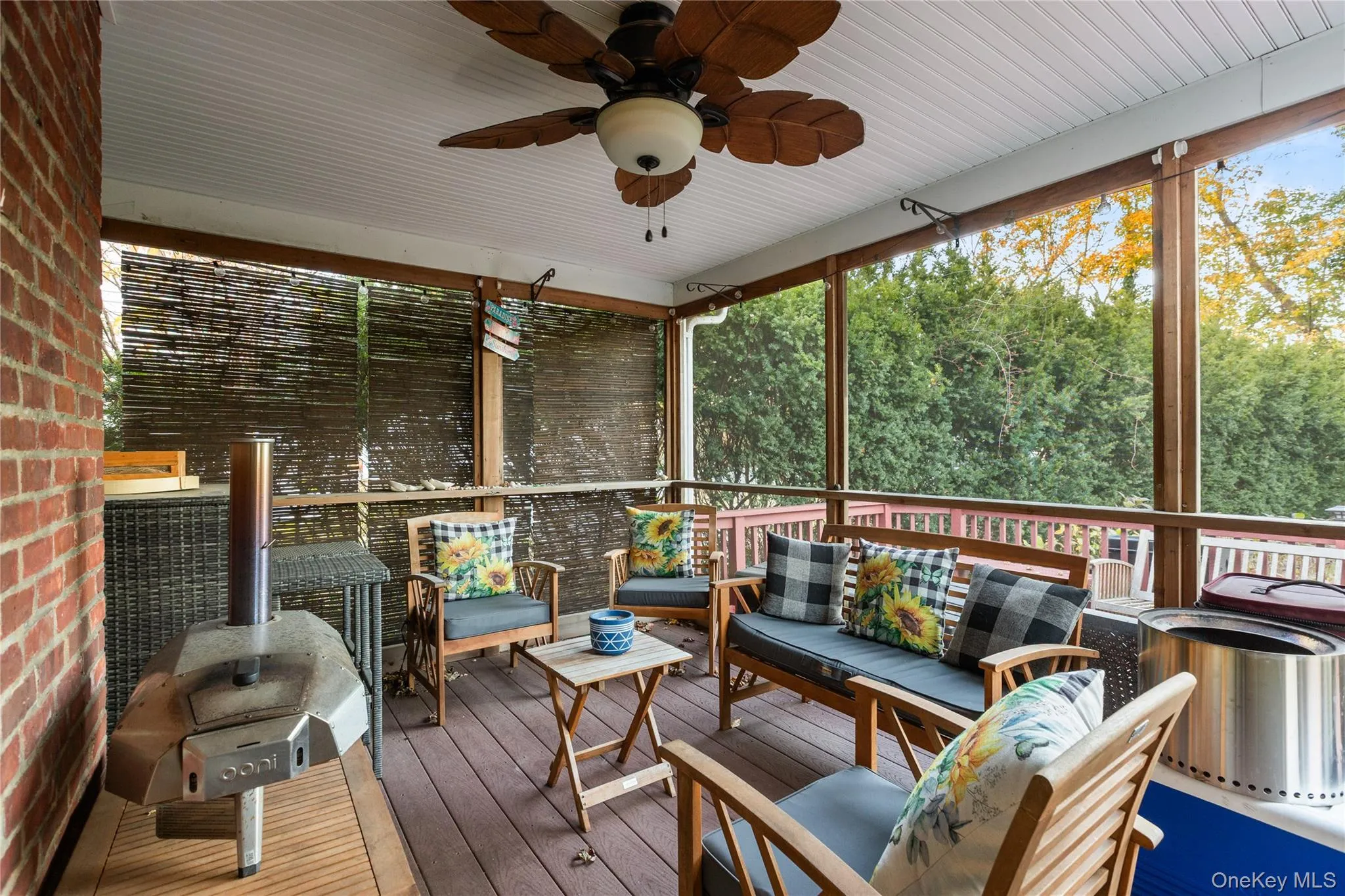 Sunroom / solarium featuring an outdoor hangout area, a ceiling fan, a deck, and view of wooded area Sunroom / solarium featuring an outdoor hangout area, a ceiling fan, a deck, and view of wooded area