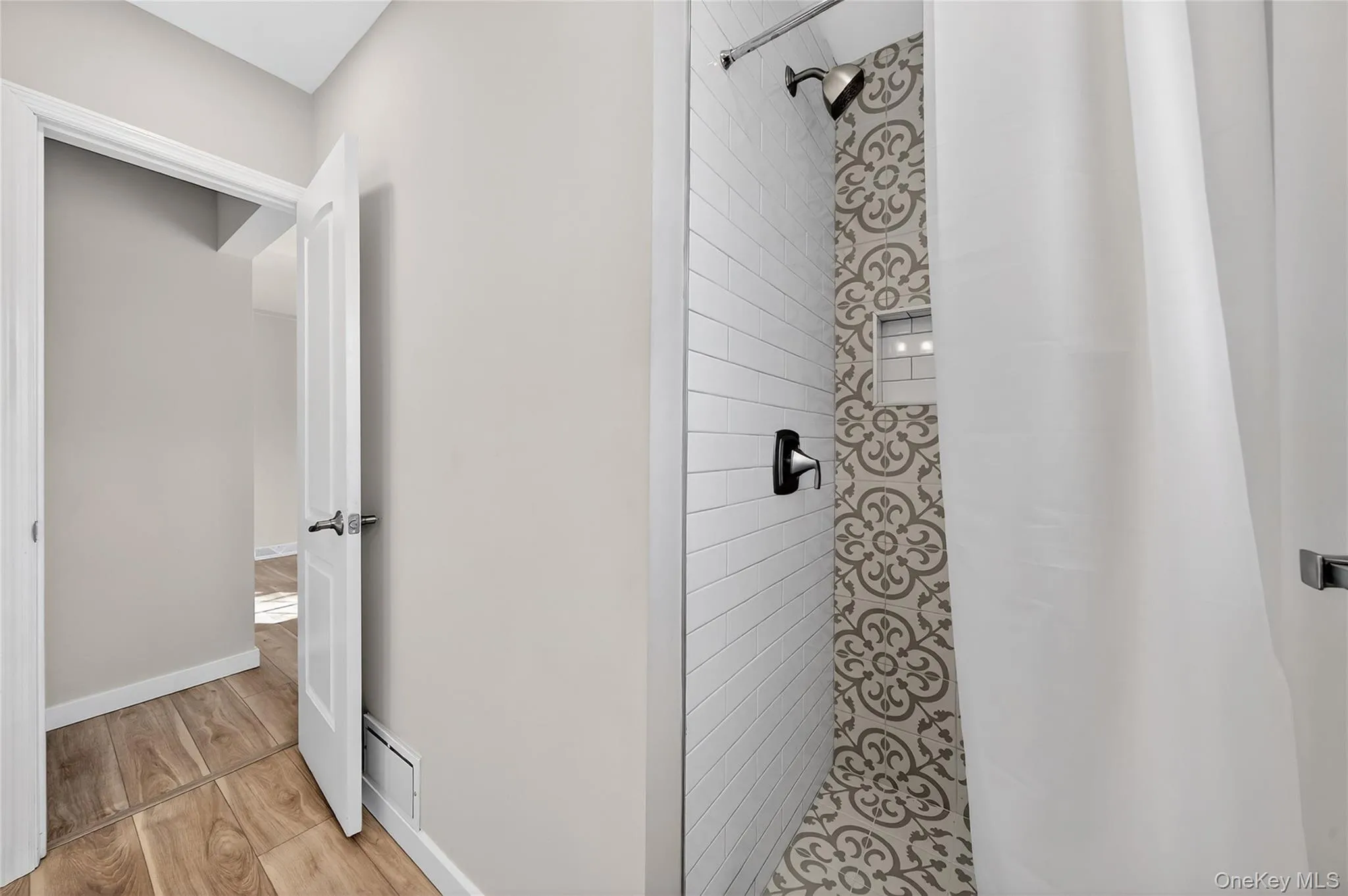 Full bath featuring a shower stall and light wood-type flooring Full bath featuring a shower stall and light wood-type flooring