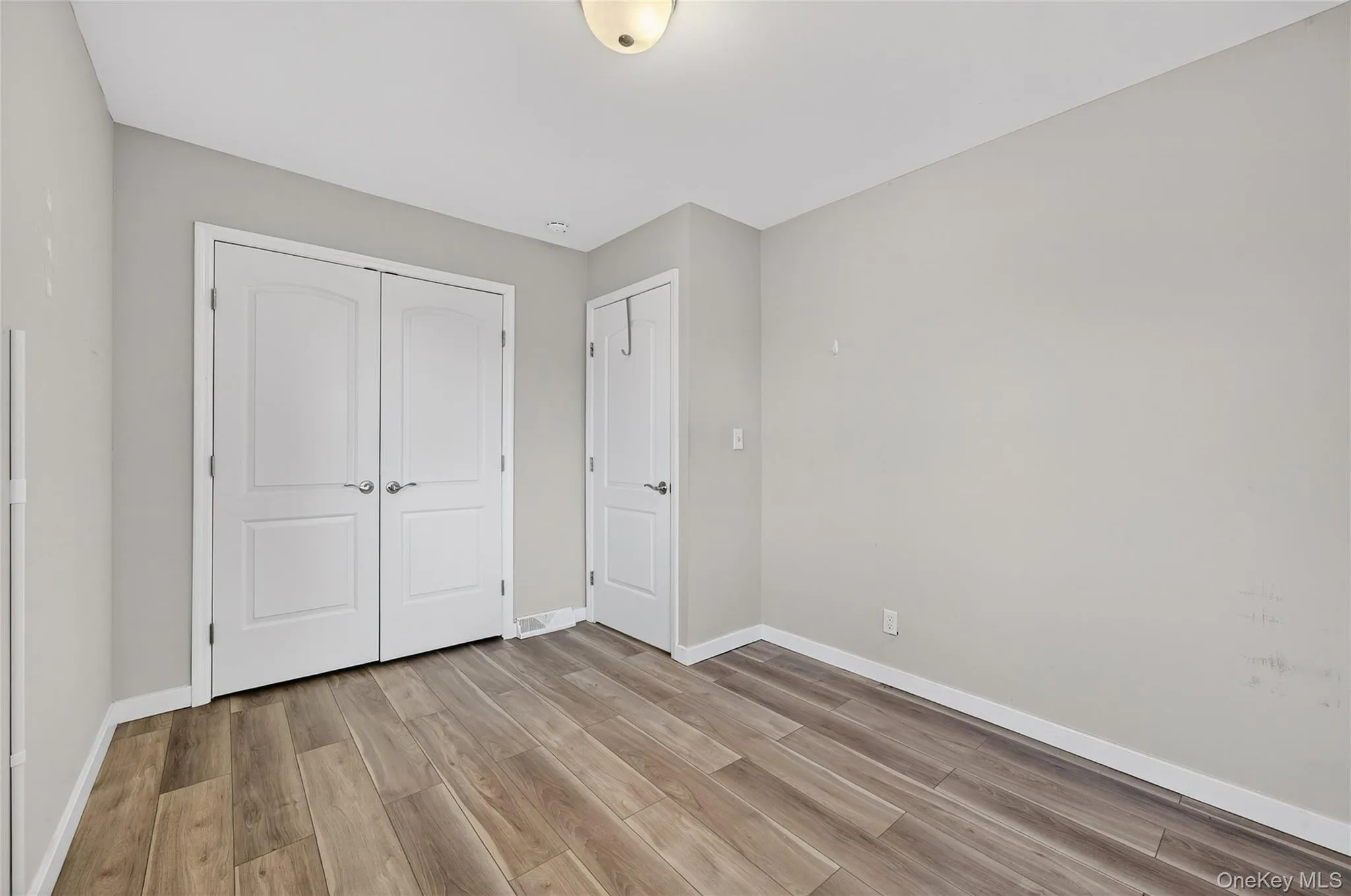Unfurnished bedroom with a closet and light wood-type flooring Unfurnished bedroom with a closet and light wood-type flooring
