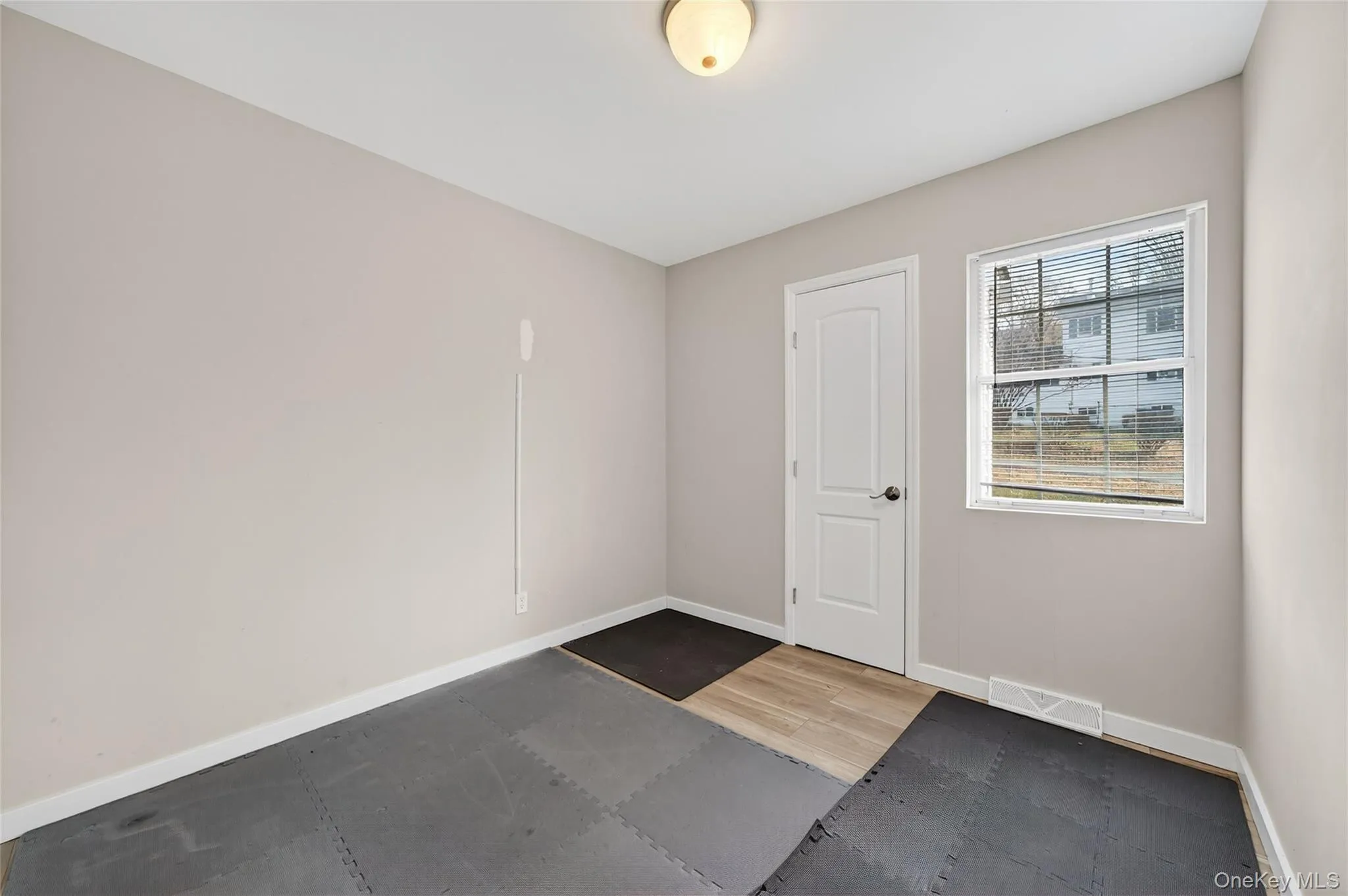 Empty room with baseboards and light wood-style flooring Empty room with baseboards and light wood-style flooring