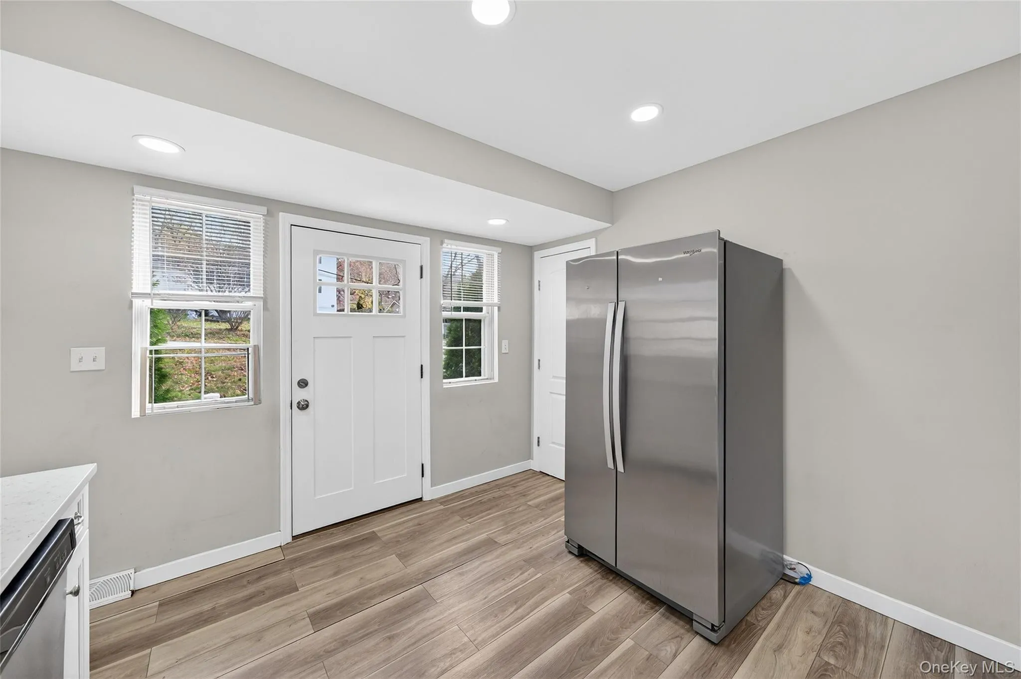 Kitchen featuring stainless steel appliances, recessed lighting, light wood-style flooring, and white cabinetry Kitchen featuring stainless steel appliances, recessed lighting, light wood-style flooring, and white cabinetry