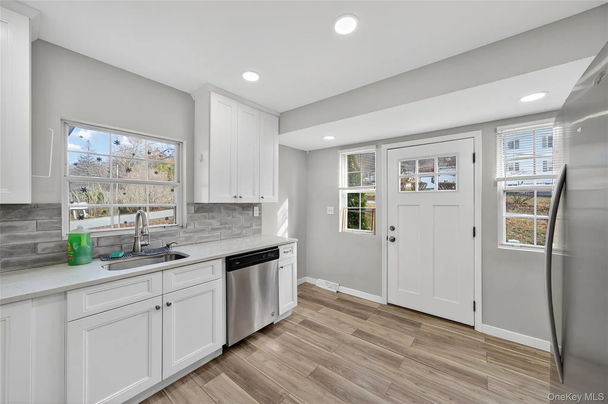 Kitchen with white cabinets, stainless steel appliances, light wood-style flooring, plenty of natural light, and recessed lighting Kitchen with white cabinets, stainless steel appliances, light wood-style flooring, plenty of natural light, and recessed lighting