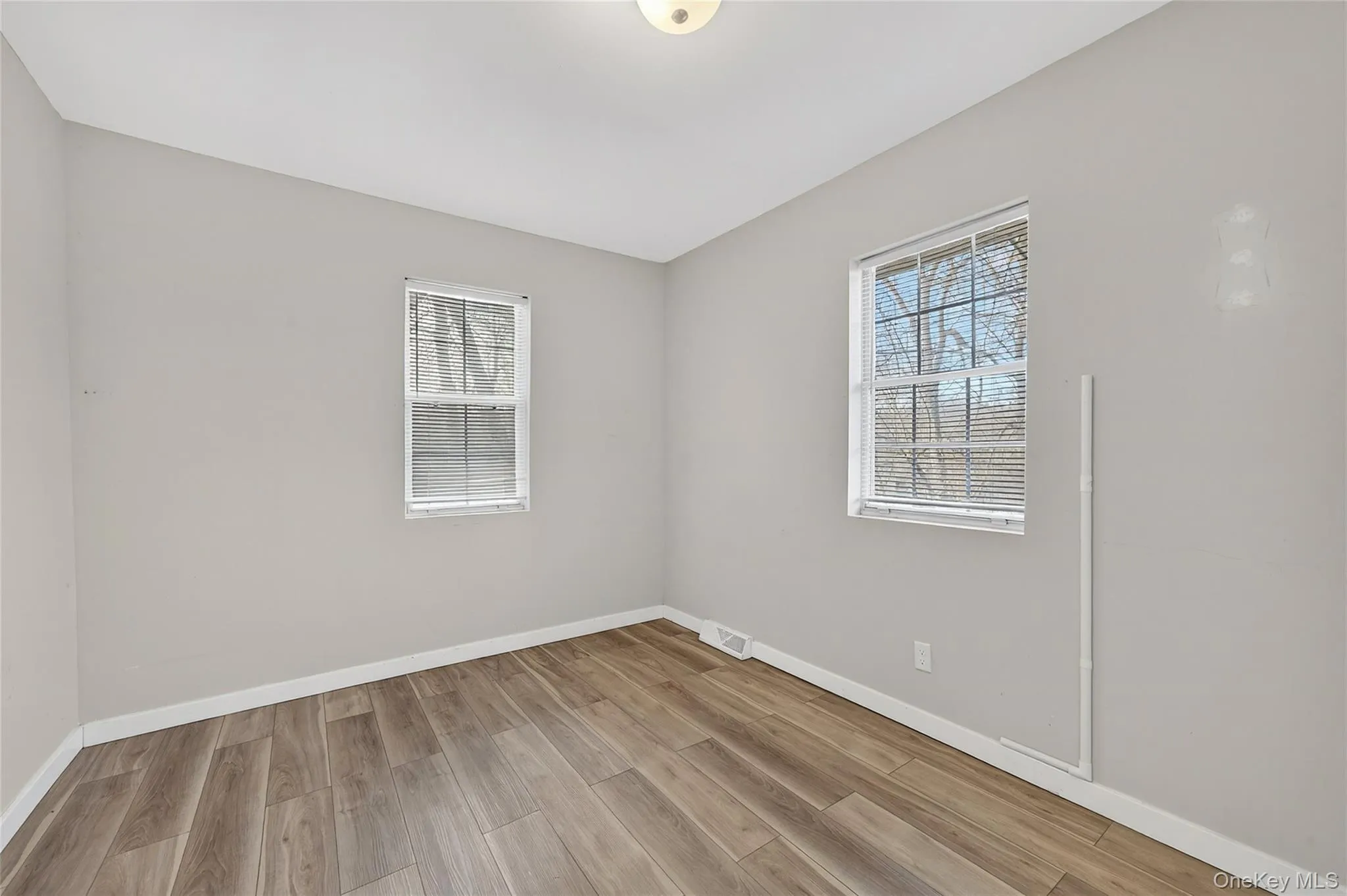 Spare room with baseboards and light wood-style floors Spare room with baseboards and light wood-style floors