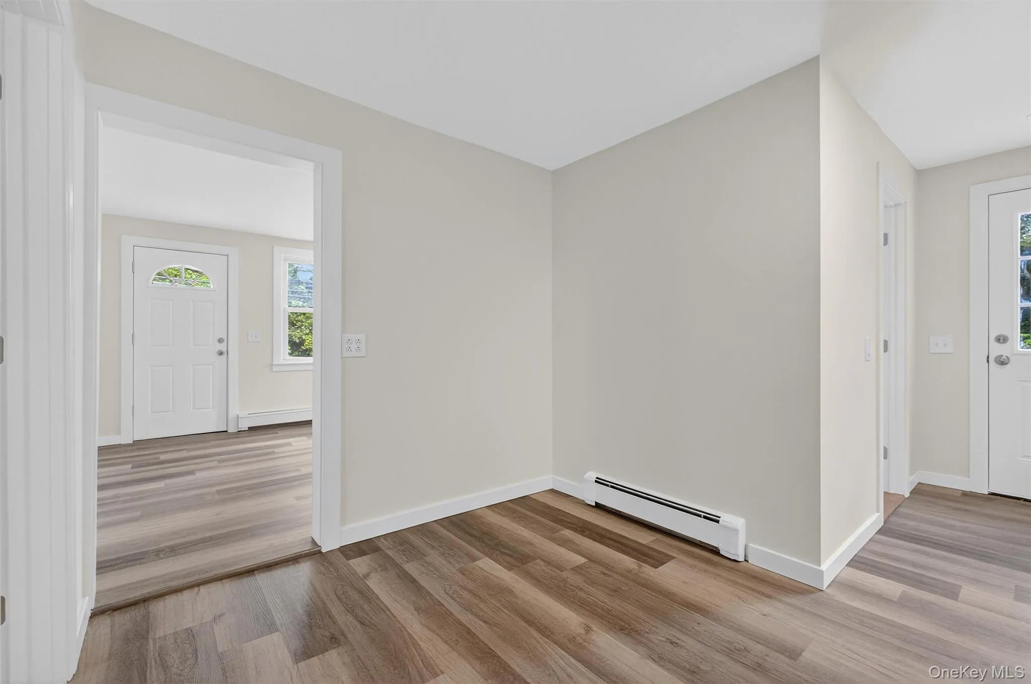 Entrance foyer featuring a baseboard heating unit and light wood-type flooring Entrance foyer featuring a baseboard heating unit and light wood-type flooring