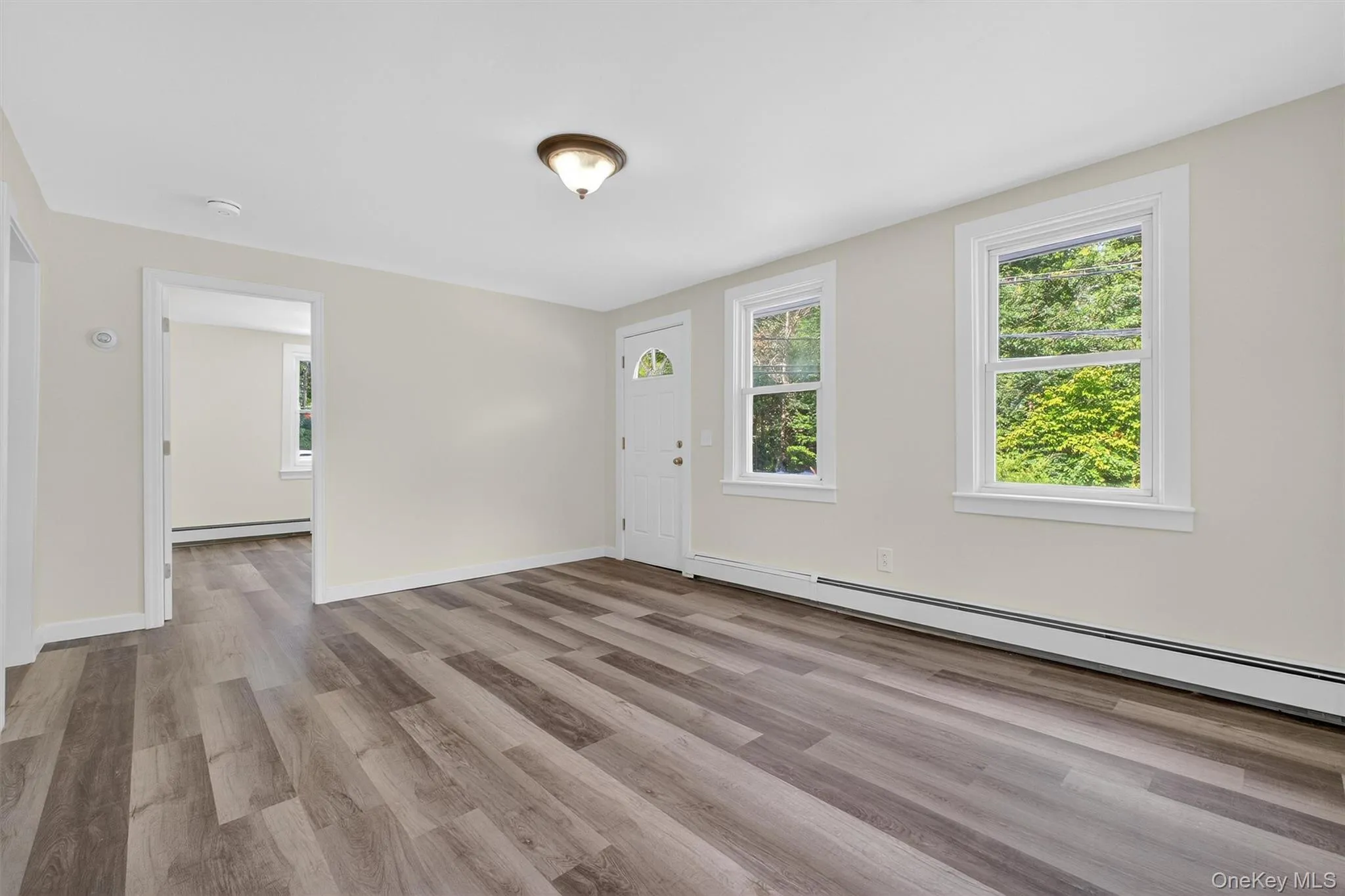 Foyer featuring light wood-type flooring and a baseboard heating unit Foyer featuring light wood-type flooring and a baseboard heating unit