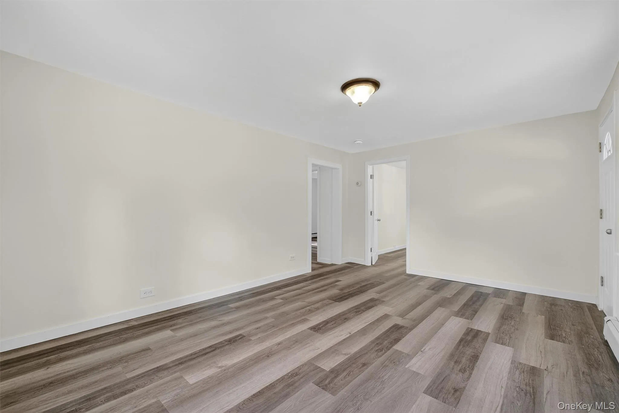 Empty room with light wood-type flooring and baseboards Empty room with light wood-type flooring and baseboards