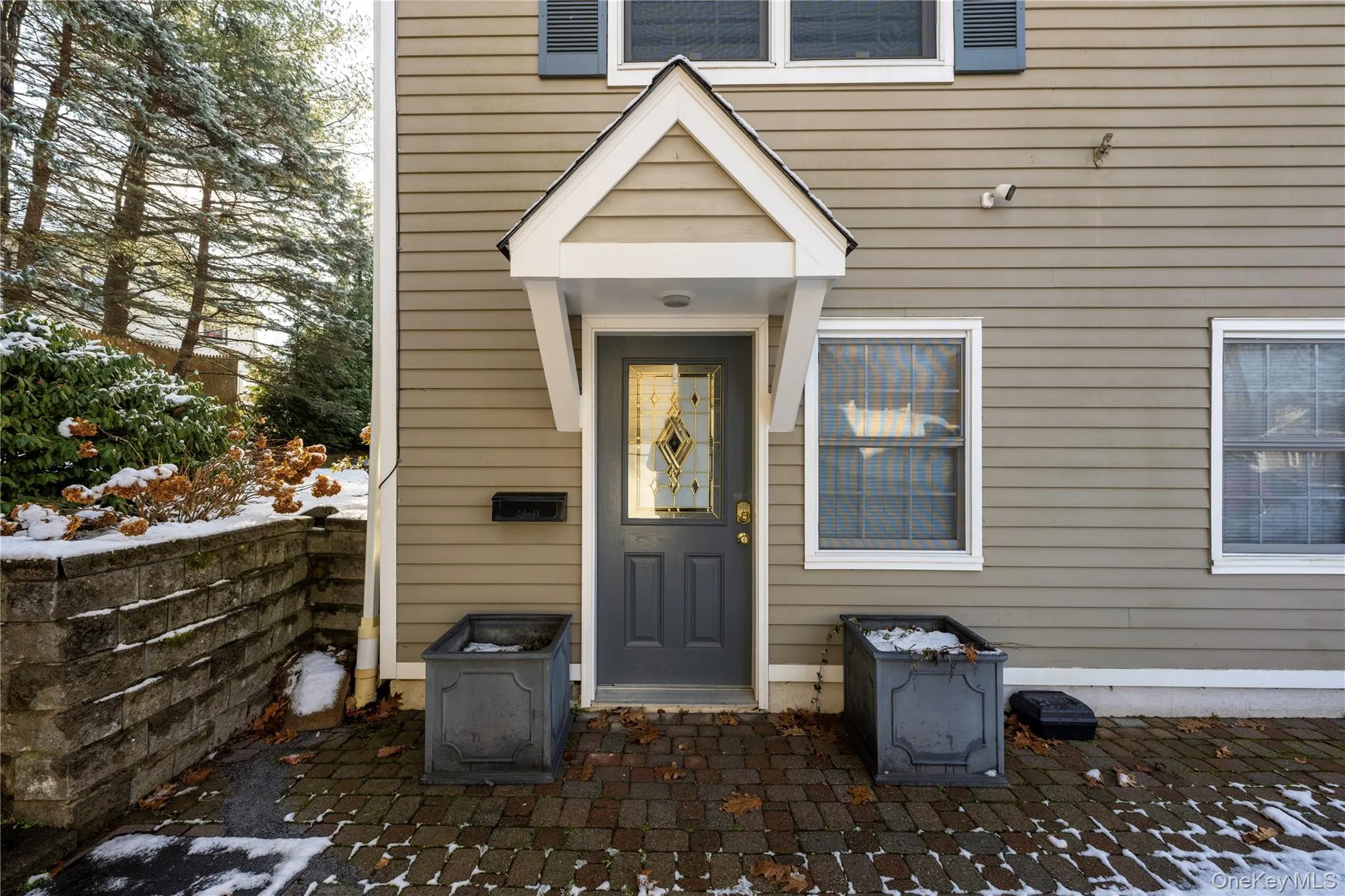 Snow covered property entrance with a patio Snow covered property entrance with a patio