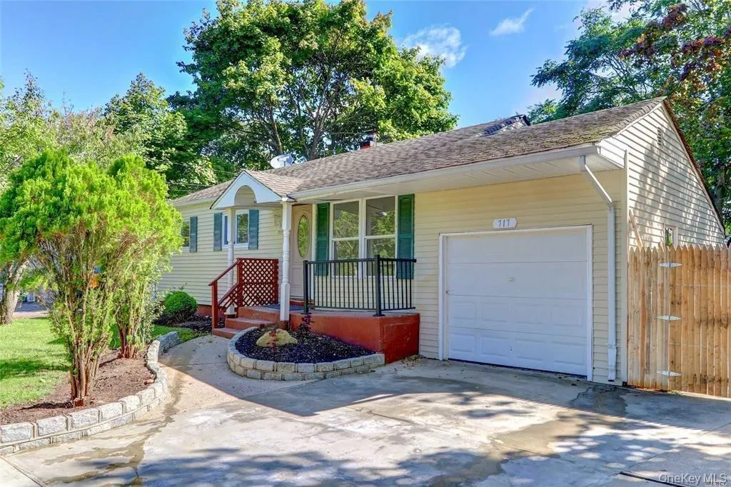 Single story home with concrete driveway, a garage, and a porch Single story home with concrete driveway, a garage, and a porch