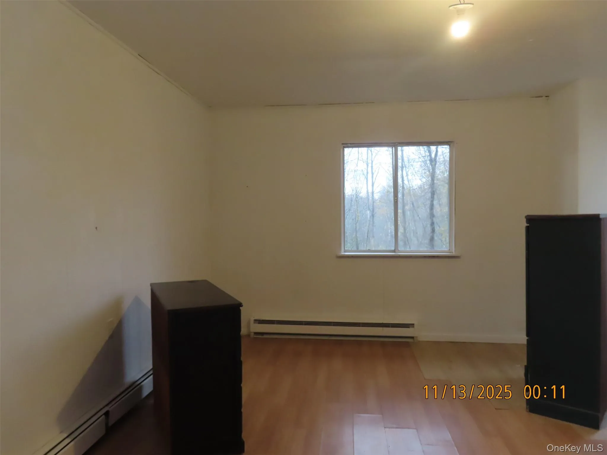 Empty room with baseboard heating and light wood-style floors Empty room with baseboard heating and light wood-style floors
