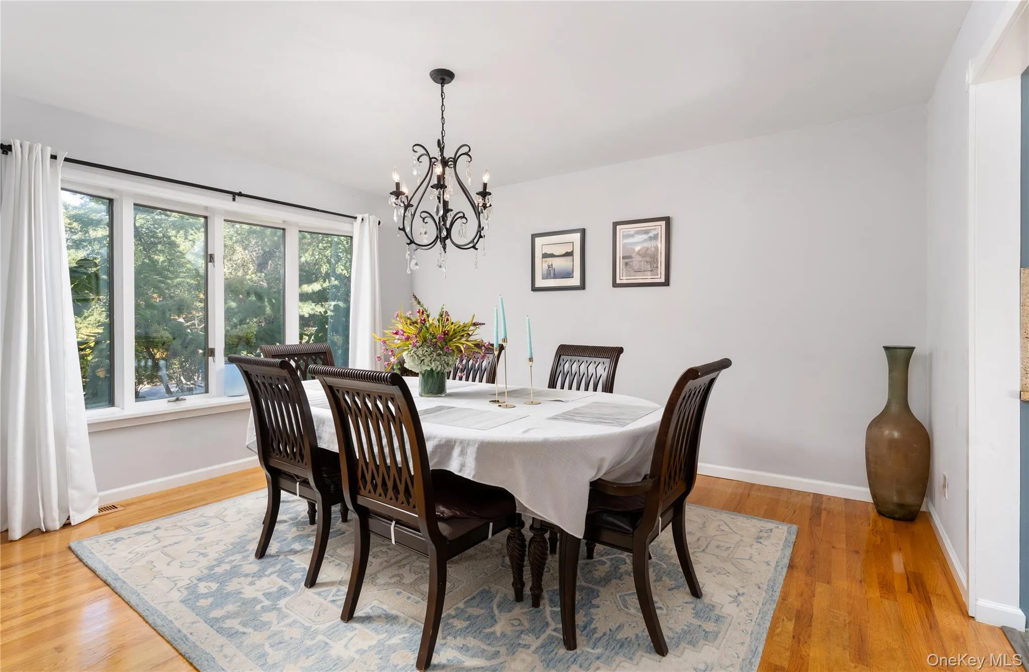Dining area featuring light wood-type flooring and a chandelier Dining area featuring light wood-type flooring and a chandelier