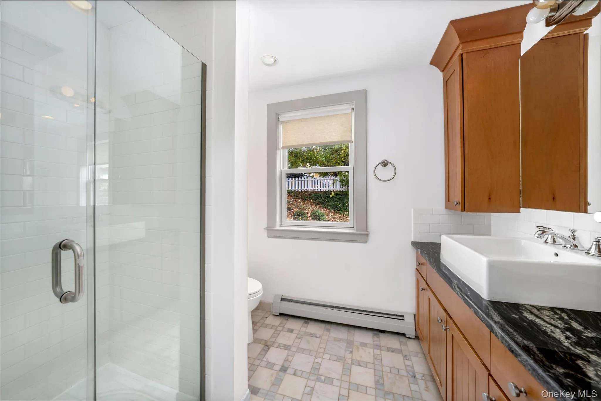 Bathroom featuring a baseboard heating unit, vanity, a stall shower, light floors, and recessed lighting Bathroom featuring a baseboard heating unit, vanity, a stall shower, light floors, and recessed lighting