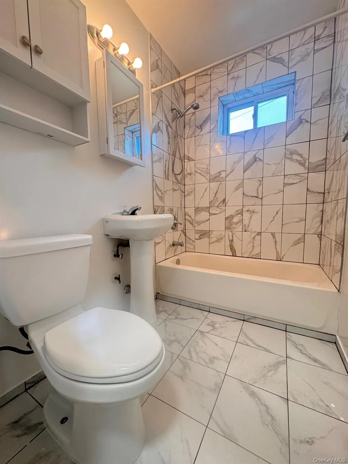 Bathroom with light marble finish flooring and shower / tub combination Bathroom with light marble finish flooring and shower / tub combination