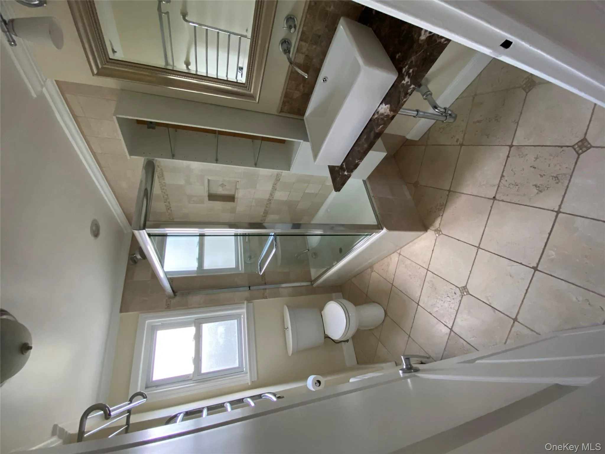 Bathroom with light tile patterned floors, ornamental molding, and enclosed tub / shower combo Bathroom with light tile patterned floors, ornamental molding, and enclosed tub / shower combo