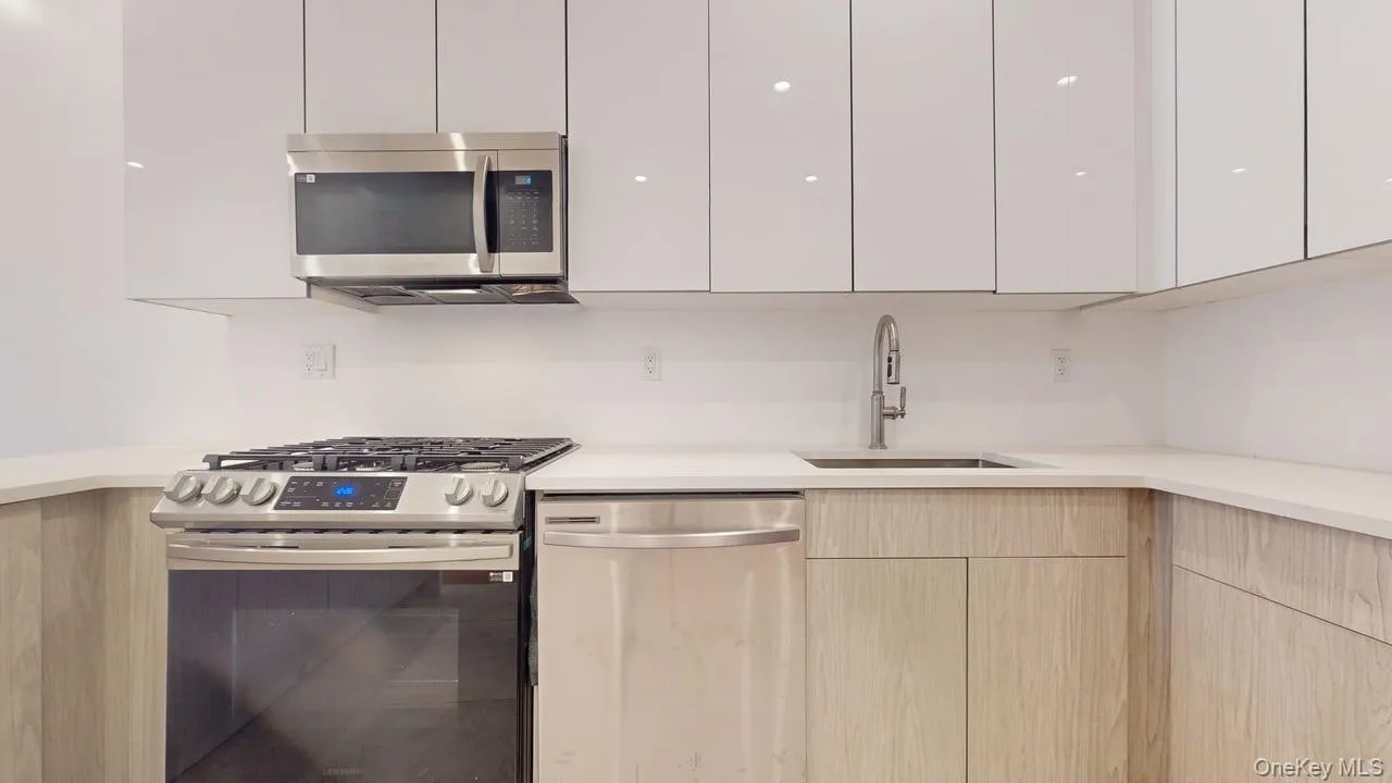 Kitchen with stainless steel appliances, modern cabinets, and white cabinets Kitchen with stainless steel appliances, modern cabinets, and white cabinets