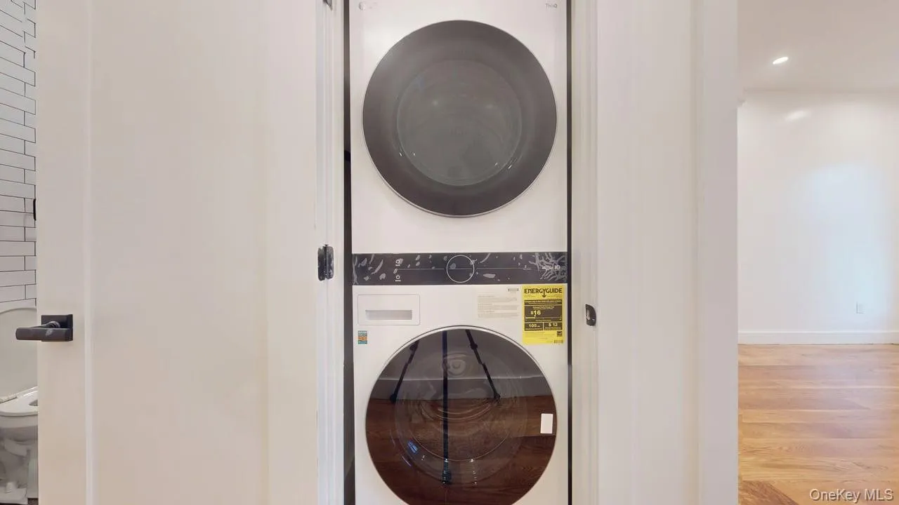 Laundry room featuring estacked washer and dryer and wood finished floors Laundry room featuring estacked washer and dryer and wood finished floors