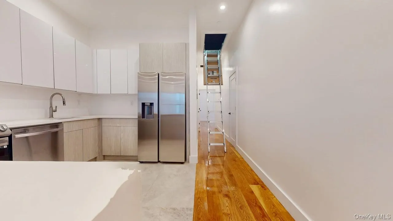 Kitchen with modern cabinets, stainless steel appliances, light wood-style floors, and white cabinetry Kitchen with modern cabinets, stainless steel appliances, light wood-style floors, and white cabinetry