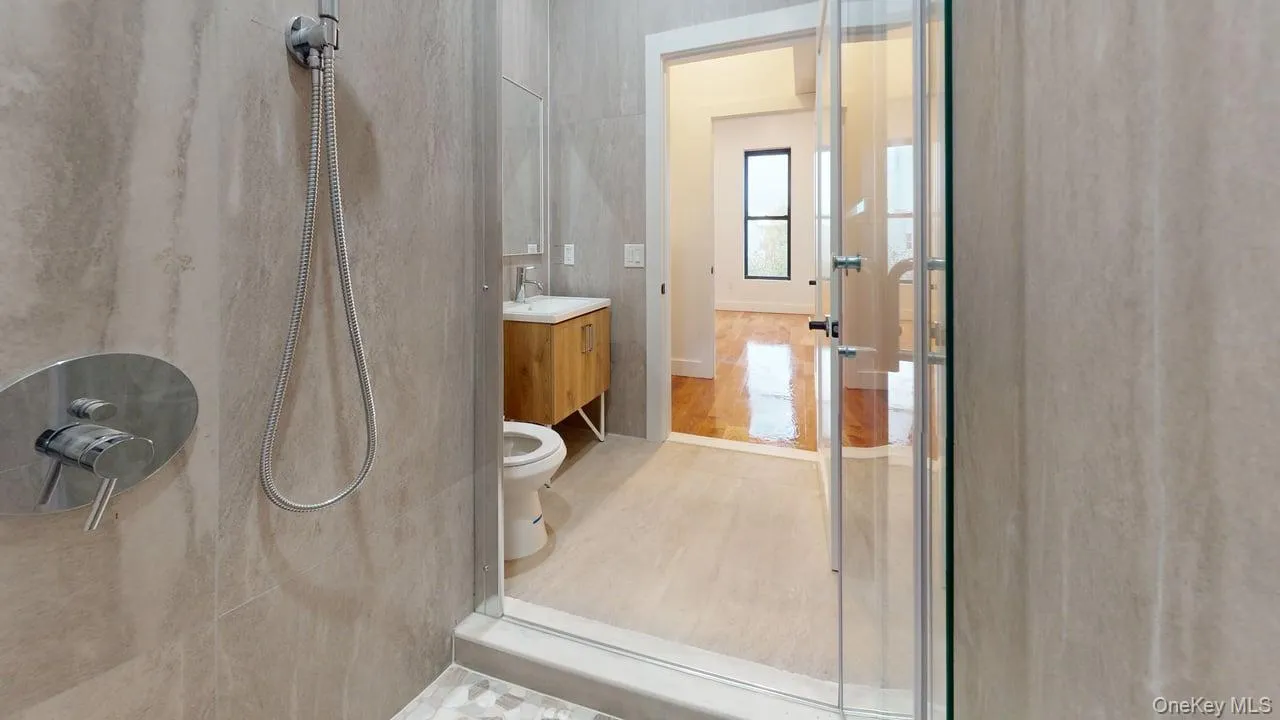 Bathroom featuring vanity and a shower Bathroom featuring vanity and a shower