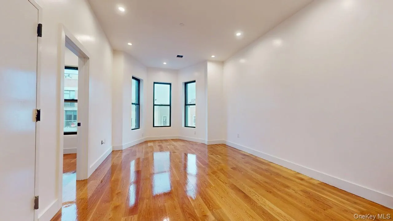 Empty room with healthy amount of natural light, light wood-style floors, and recessed lighting Empty room with healthy amount of natural light, light wood-style floors, and recessed lighting