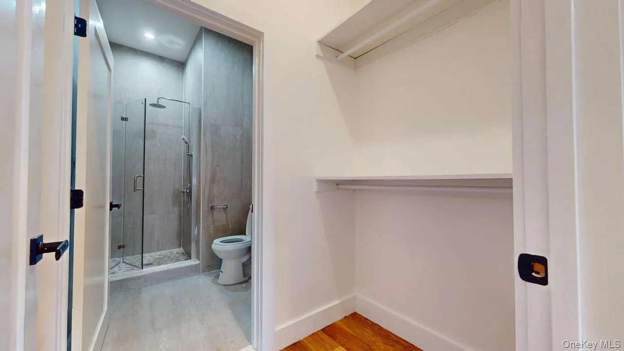 Full bath with a shower stall and light wood-style flooring Full bath with a shower stall and light wood-style flooring