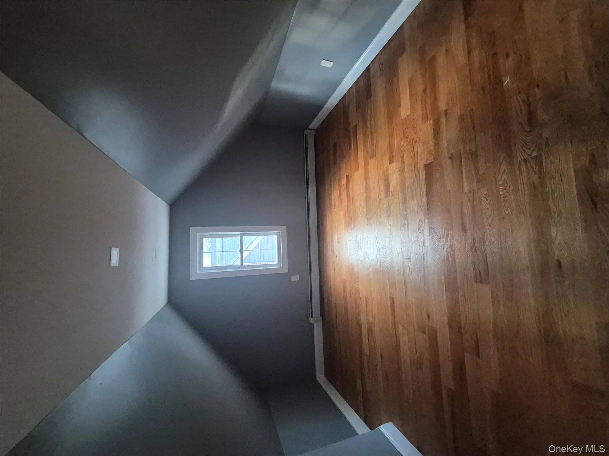 Bonus room featuring wood finished floors, vaulted ceiling, and a baseboard heating unit Bonus room featuring wood finished floors, vaulted ceiling, and a baseboard heating unit