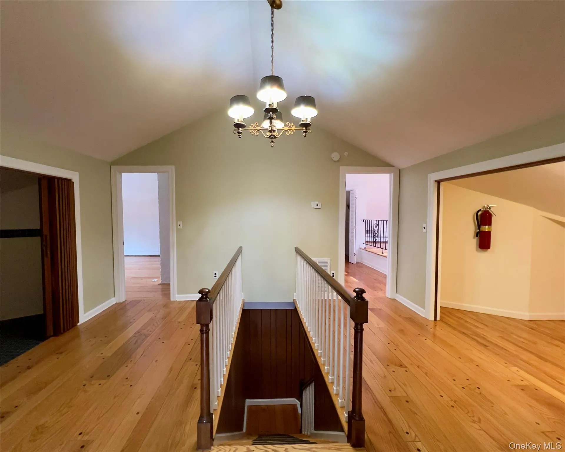 Stairs leading to 3 bedrooms with a chandelier, hardwood flooring, and lofted ceiling Stairs leading to 3 bedrooms with a chandelier, hardwood flooring, and lofted ceiling