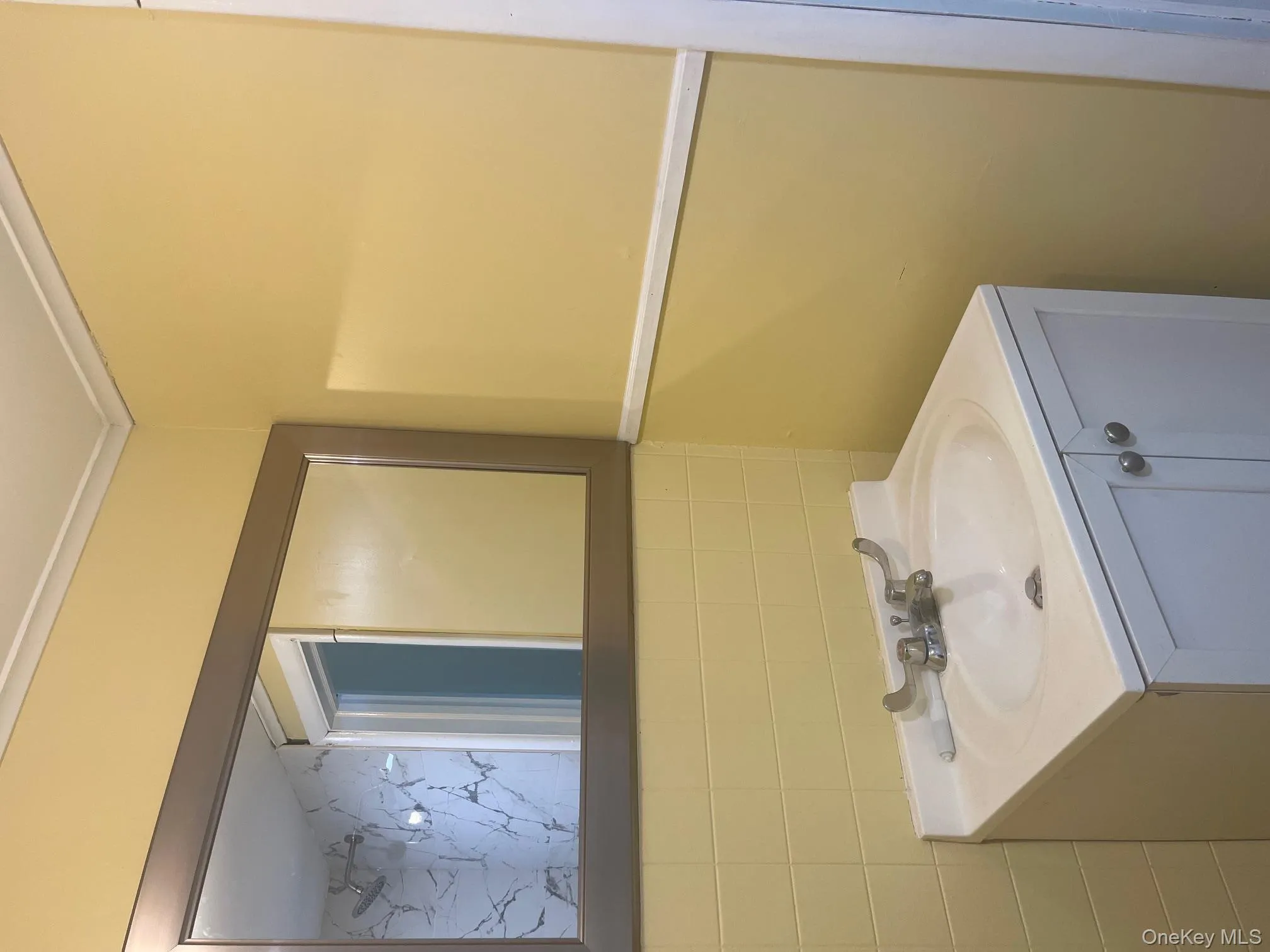 Bathroom featuring vanity, ornamental molding, tile walls, and decorative backsplash Bathroom featuring vanity, ornamental molding, tile walls, and decorative backsplash