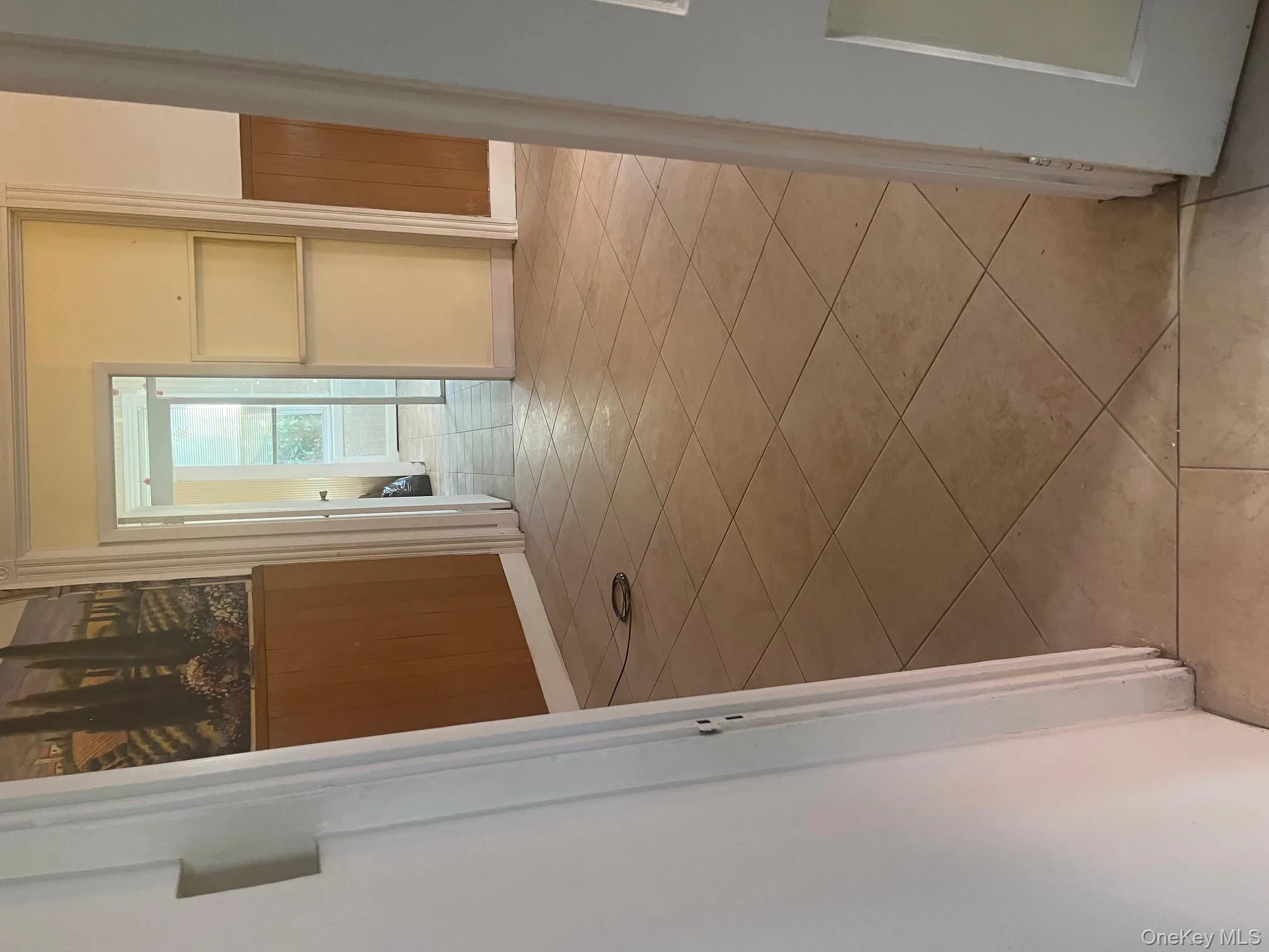 Hall with wood walls, light tile patterned flooring, and a wainscoted wall Hall with wood walls, light tile patterned flooring, and a wainscoted wall