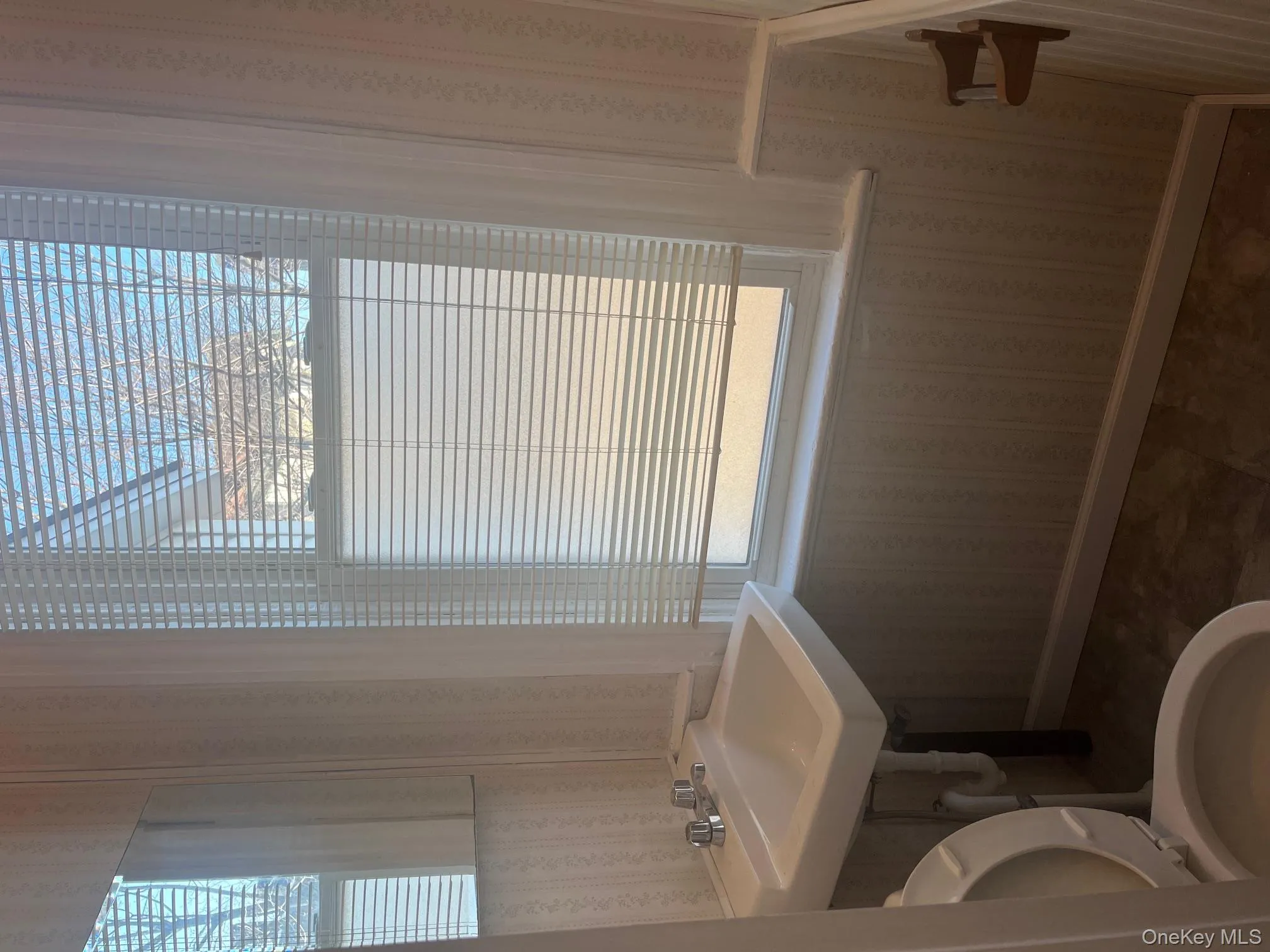 Bathroom featuring wallpapered walls Bathroom featuring wallpapered walls