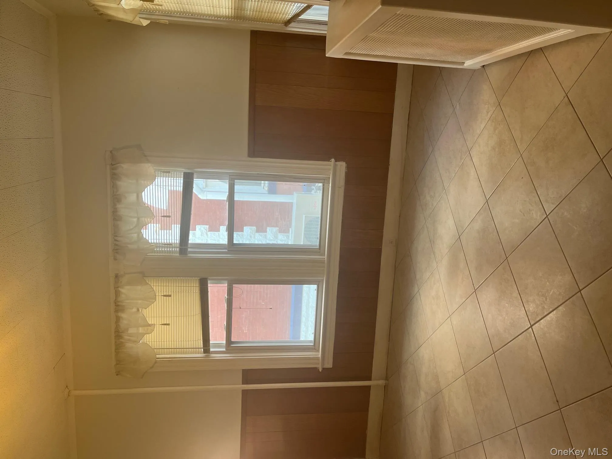 Empty room with a wainscoted wall, wooden walls, ornamental molding, healthy amount of natural light, and light tile patterned floors Empty room with a wainscoted wall, wooden walls, ornamental molding, healthy amount of natural light, and light tile patterned floors
