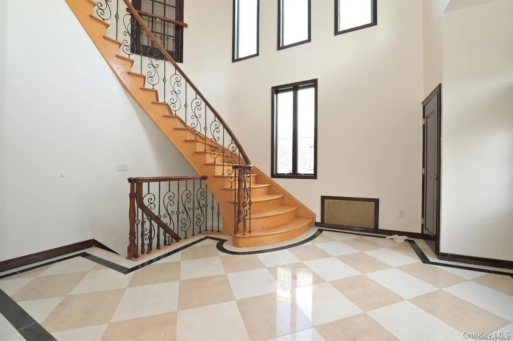 Stairway featuring a high ceiling and baseboards Stairway featuring a high ceiling and baseboards