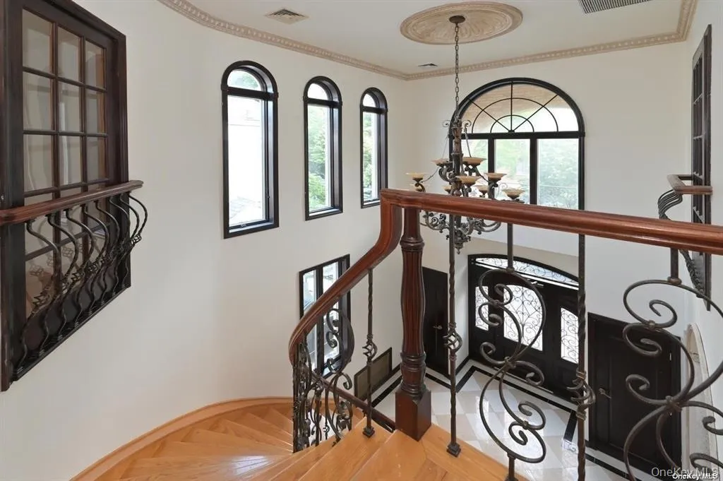 Staircase featuring a chandelier and crown molding Staircase featuring a chandelier and crown molding
