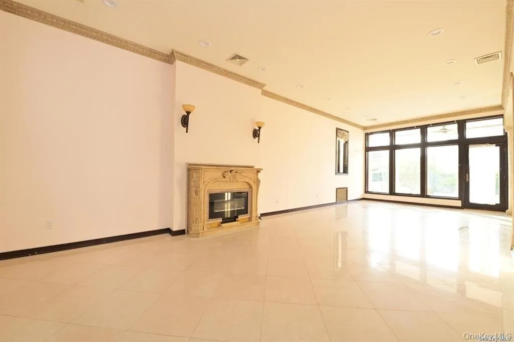 Unfurnished living room with a glass covered fireplace, ornamental molding, and light tile patterned flooring Unfurnished living room with a glass covered fireplace, ornamental molding, and light tile patterned flooring