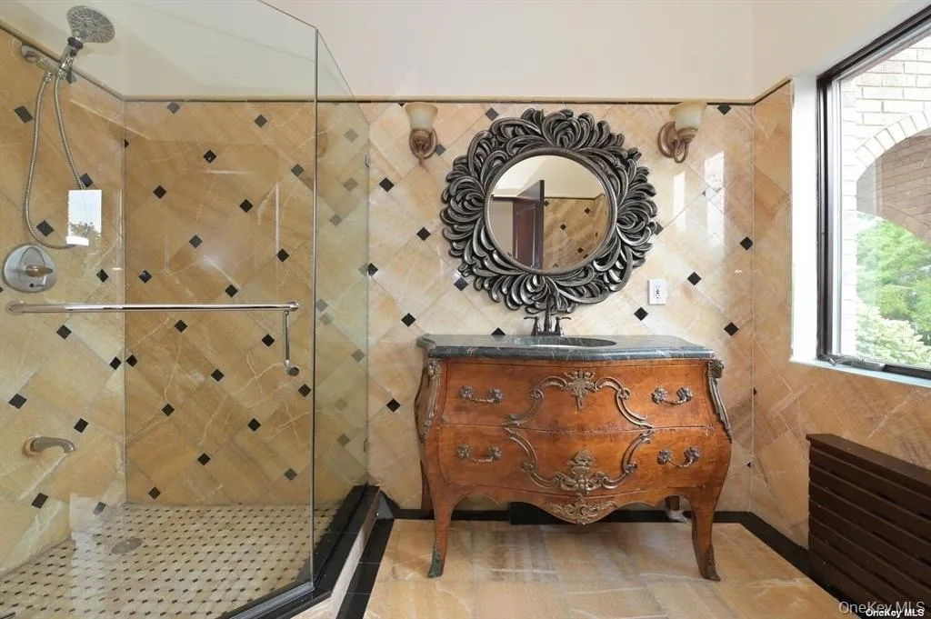 Full bath featuring plenty of natural light, vanity, a stall shower, and tile walls Full bath featuring plenty of natural light, vanity, a stall shower, and tile walls