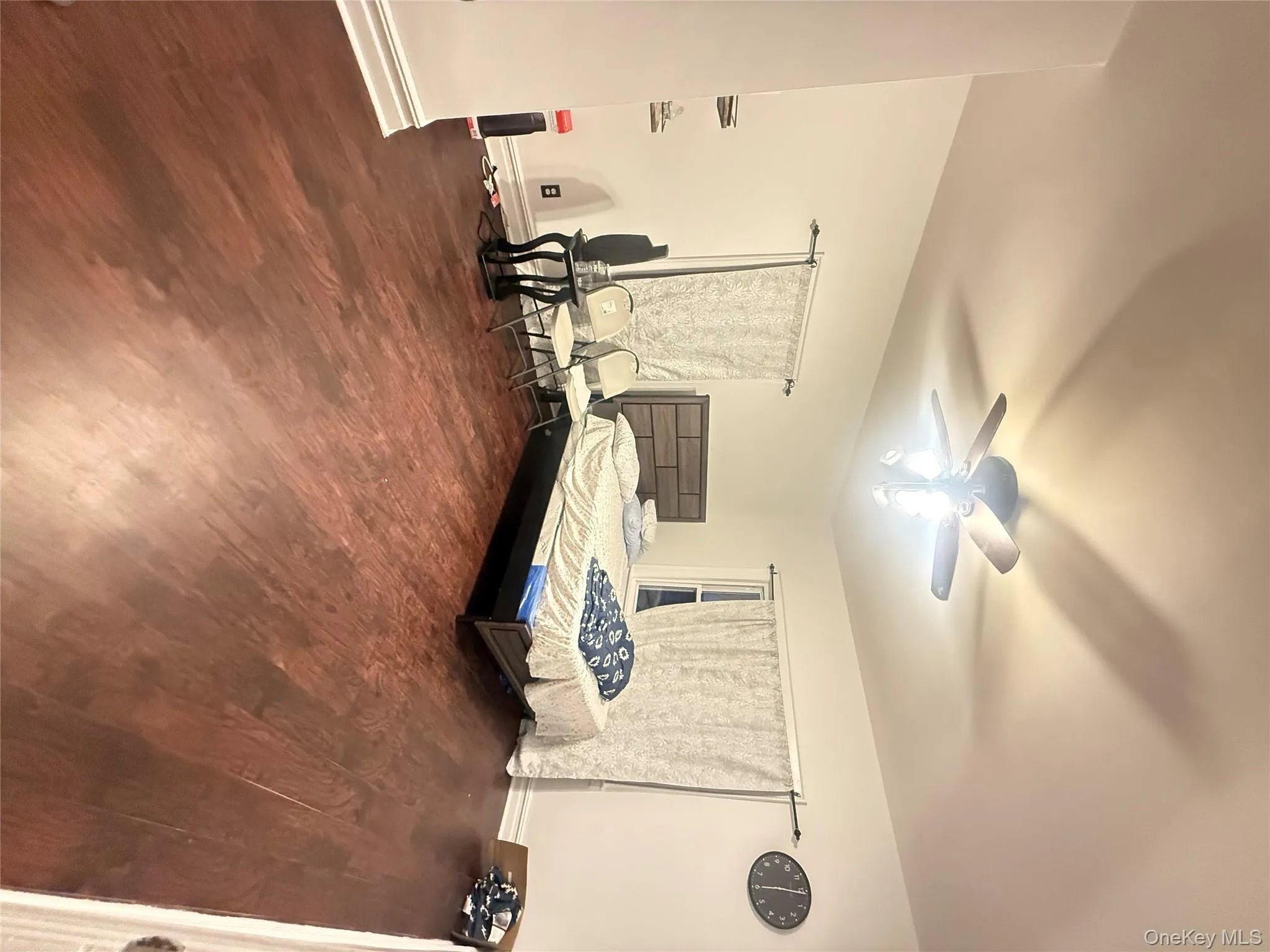 Bedroom with dark wood-type flooring and a ceiling fan Bedroom with dark wood-type flooring and a ceiling fan