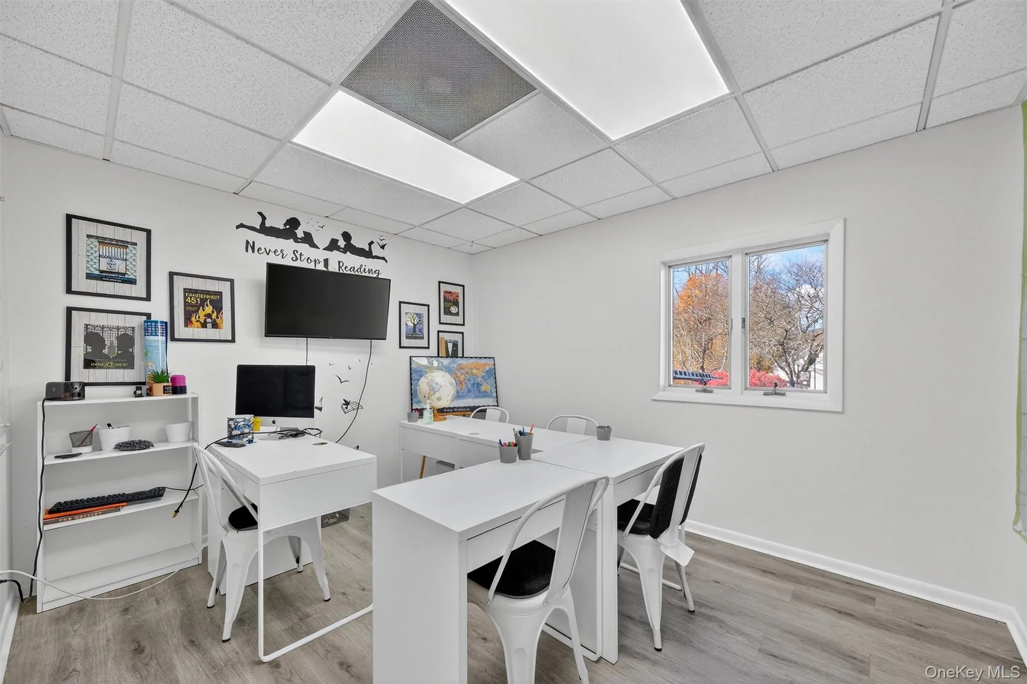 Home office with light wood-type flooring and a paneled ceiling Home office with light wood-type flooring and a paneled ceiling