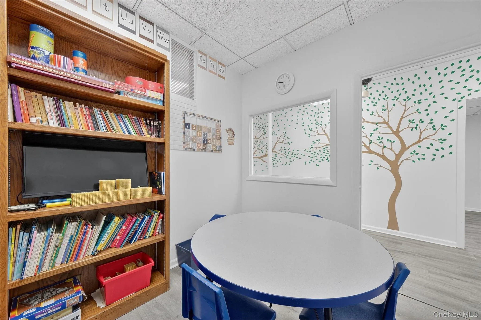 Dining area with a drop ceiling and wood finished floors Dining area with a drop ceiling and wood finished floors