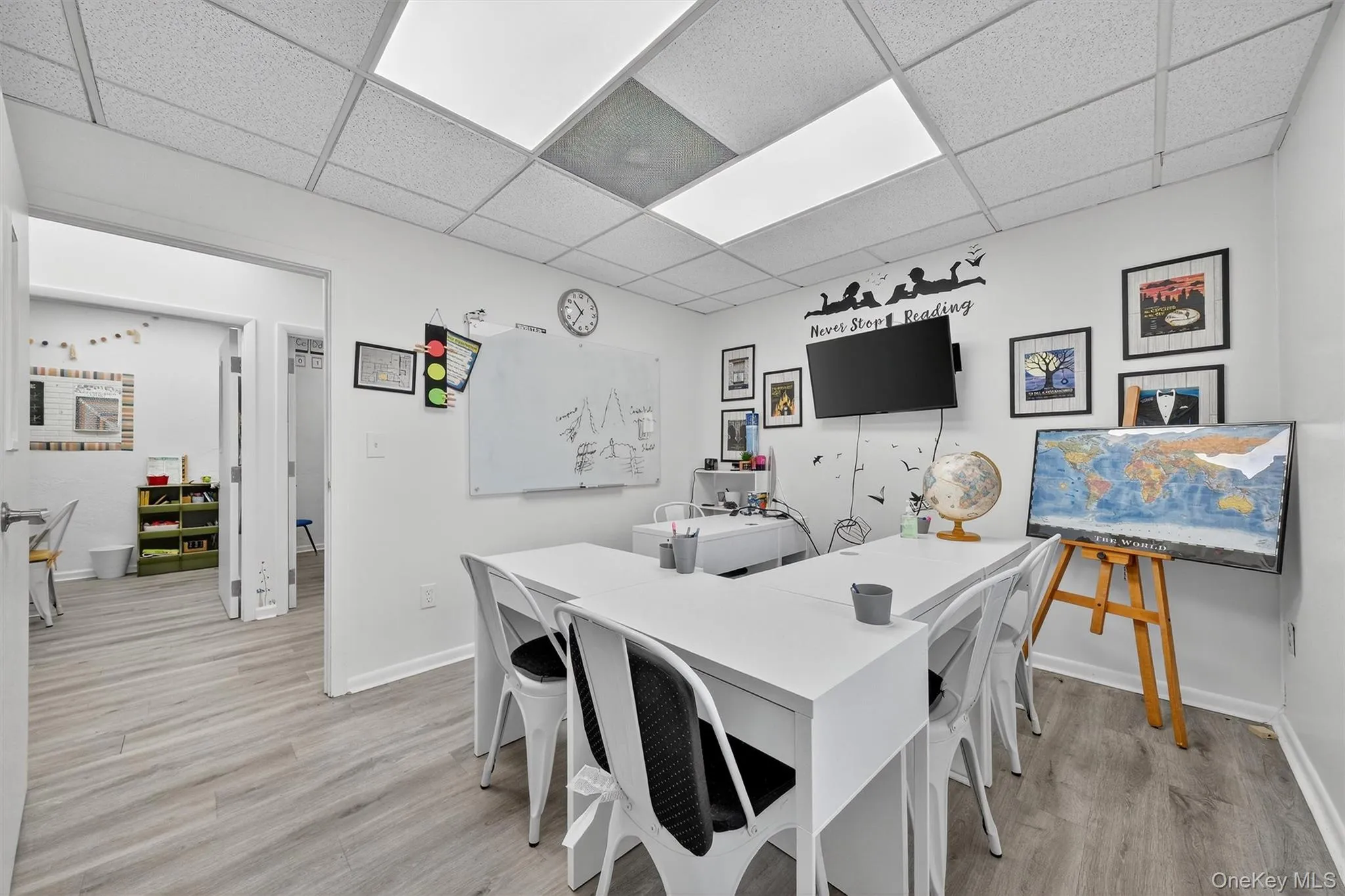 Dining space featuring light wood-type flooring, an office area, and a drop ceiling Dining space featuring light wood-type flooring, an office area, and a drop ceiling