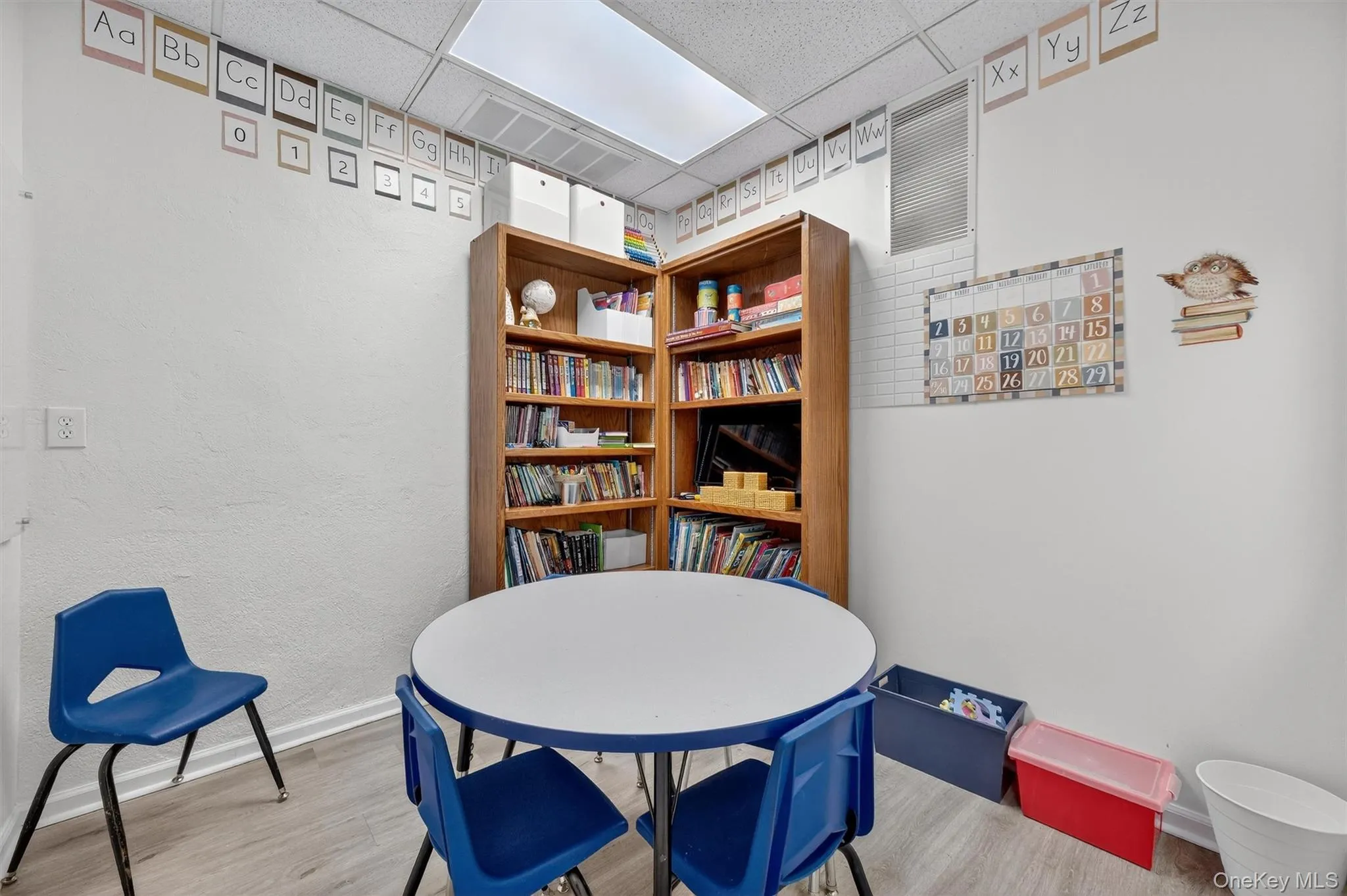 Dining room featuring a drop ceiling, wood finished floors, and a textured wall Dining room featuring a drop ceiling, wood finished floors, and a textured wall