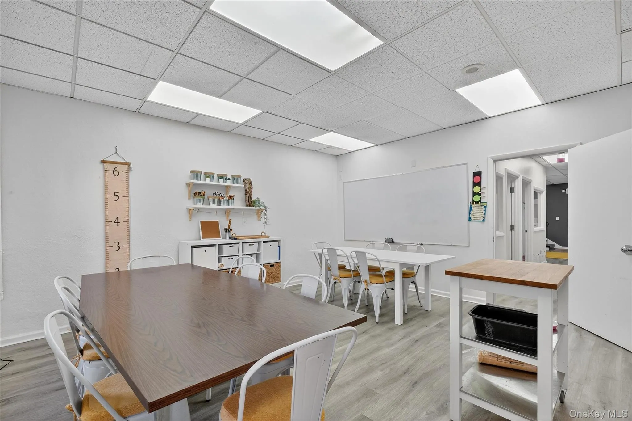 Dining area with light wood-style floors and a drop ceiling Dining area with light wood-style floors and a drop ceiling