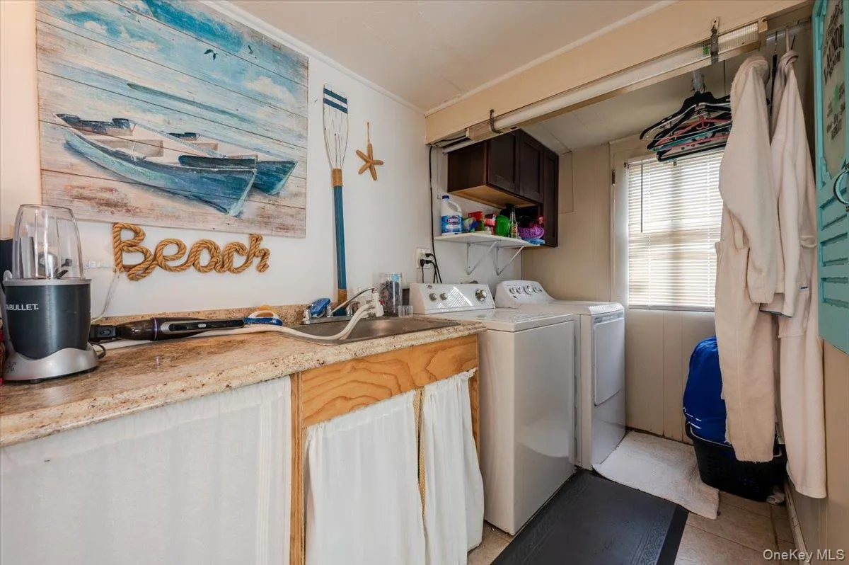 Laundry room with washer and dryer, cabinet space, and light tile patterned floors Laundry room with washer and dryer, cabinet space, and light tile patterned floors