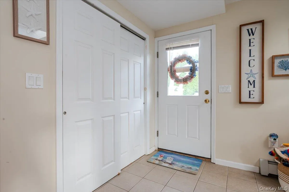 Doorway featuring tile patterned floors and baseboard heating Doorway featuring tile patterned floors and baseboard heating