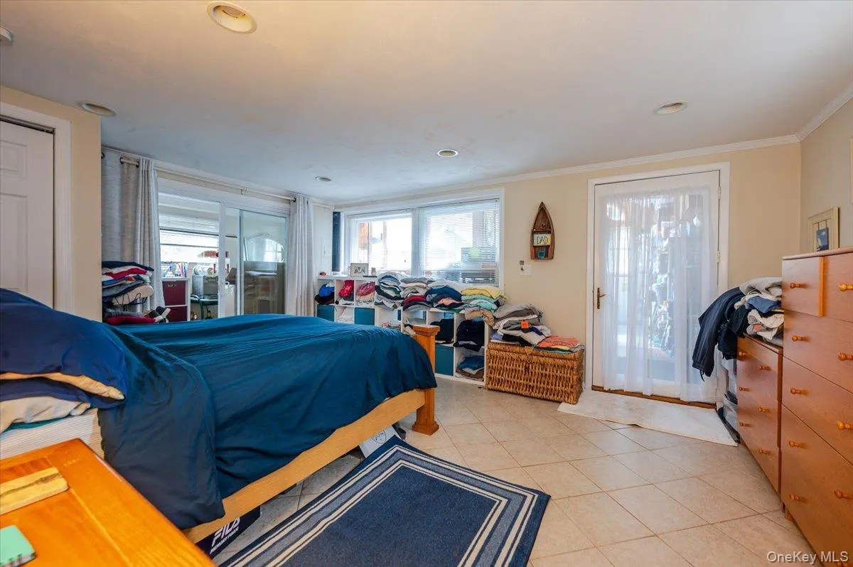 Bedroom with access to exterior, light tile patterned floors, and crown molding Bedroom with access to exterior, light tile patterned floors, and crown molding