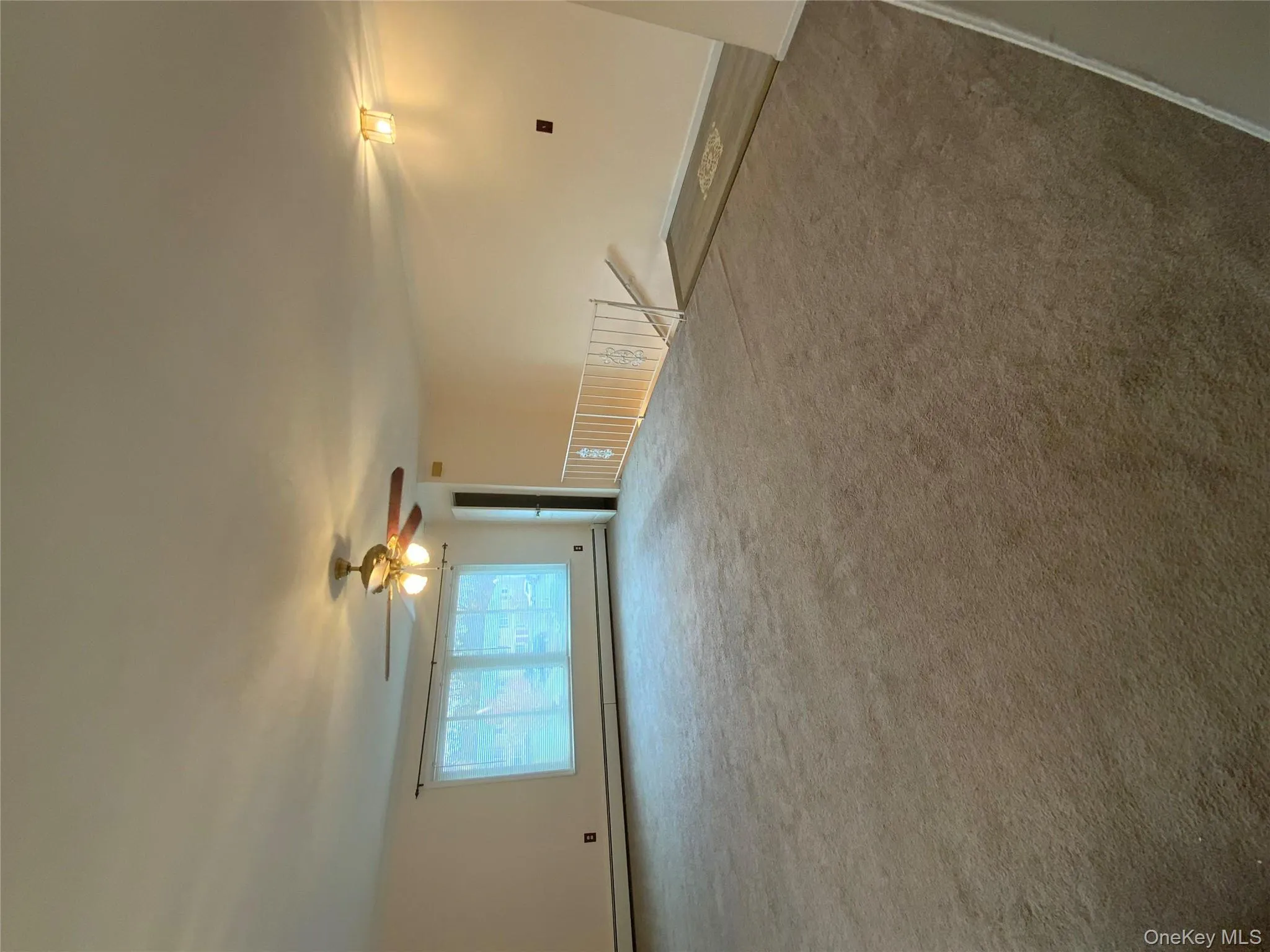 Carpeted empty room featuring baseboard heating and a ceiling fan Carpeted empty room featuring baseboard heating and a ceiling fan