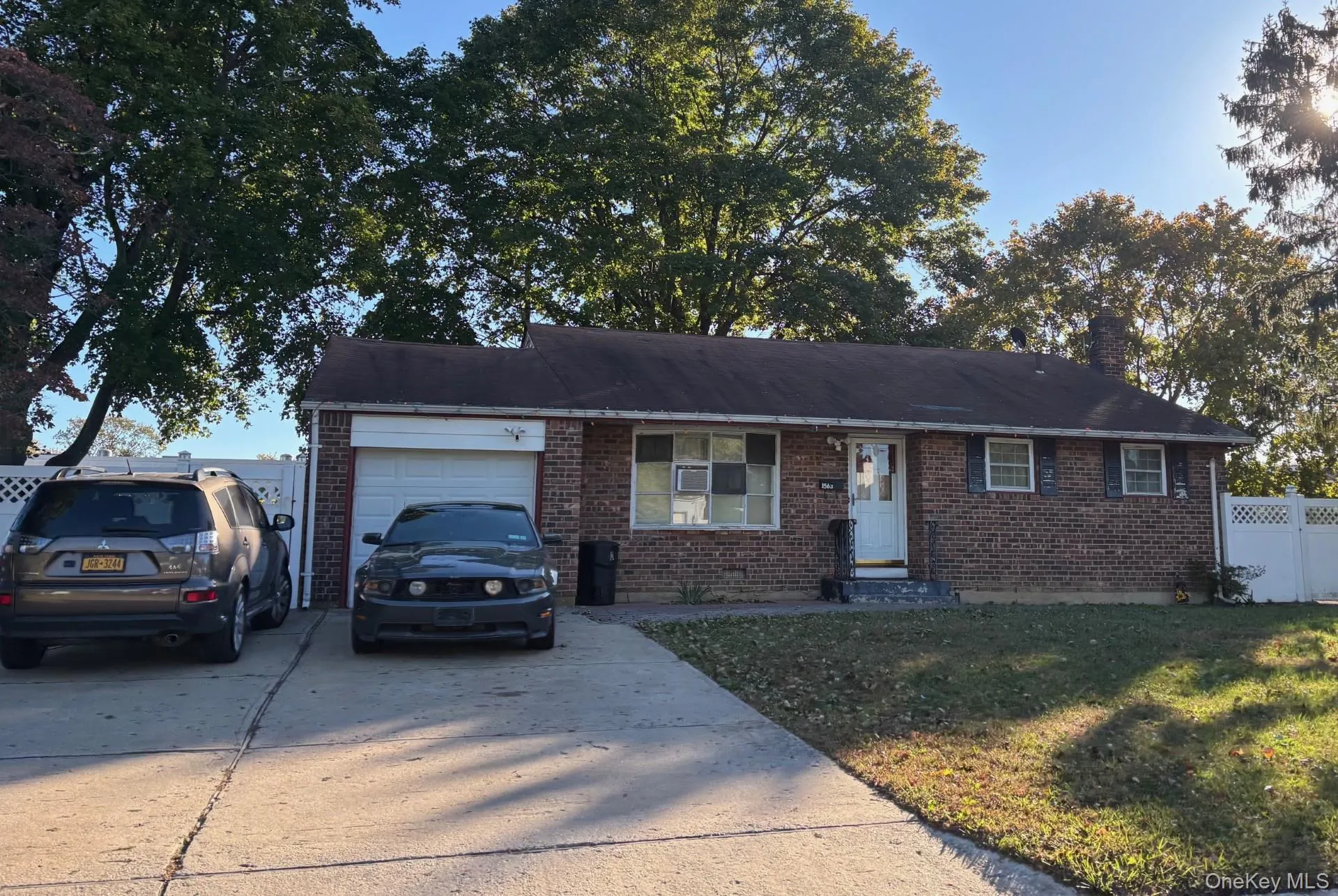 Single story home with brick siding, driveway, a garage, and a chimney Single story home with brick siding, driveway, a garage, and a chimney