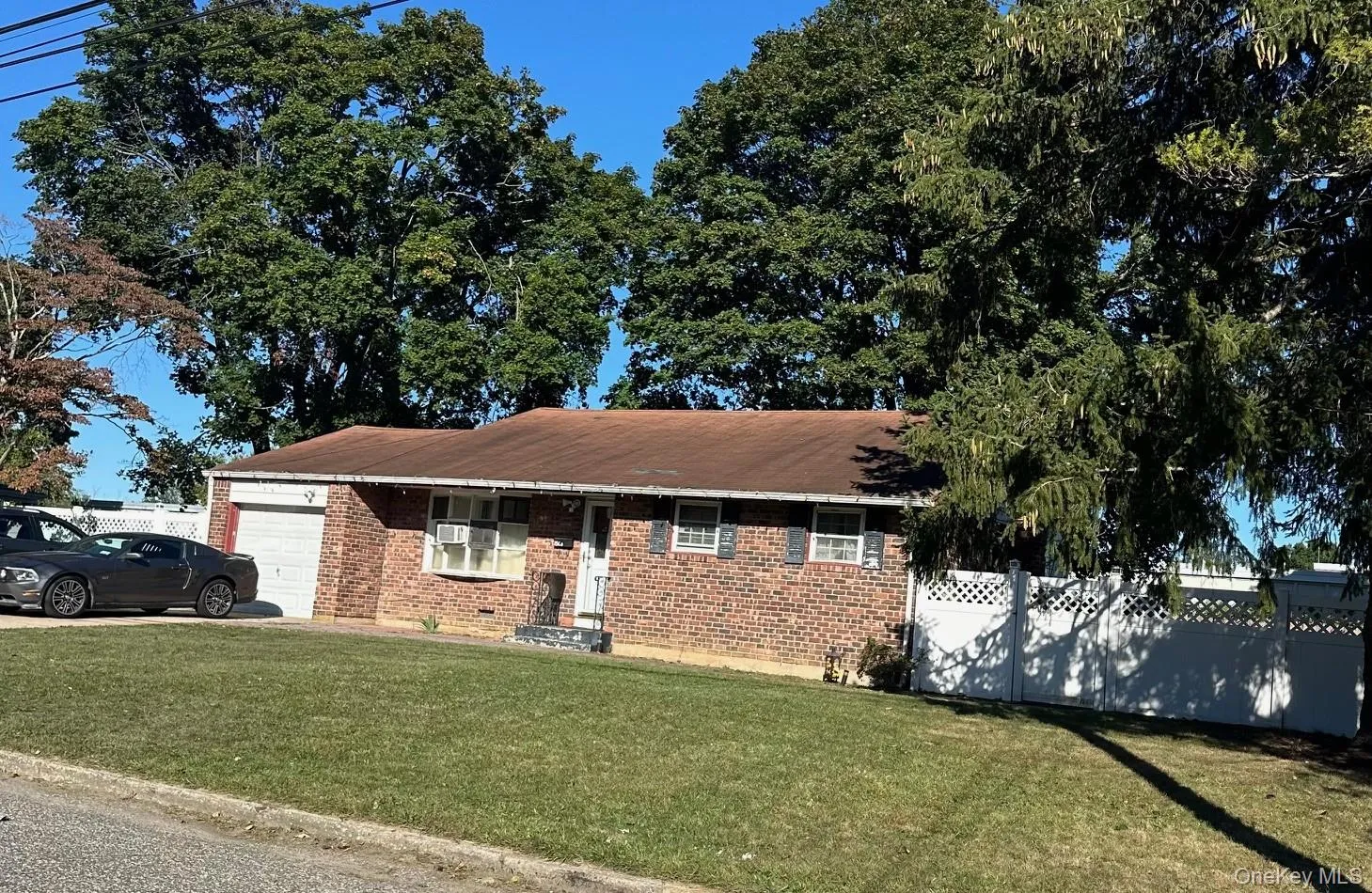 Ranch-style home featuring brick siding and a garage Ranch-style home featuring brick siding and a garage