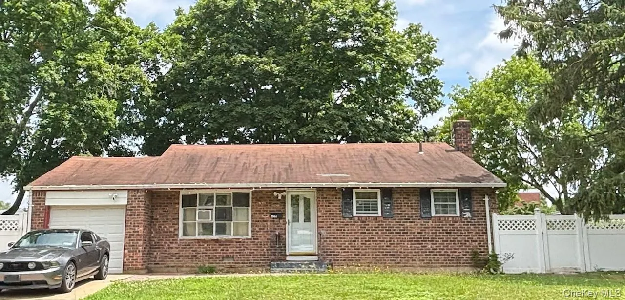 Ranch-style home featuring an attached garage, brick siding, a chimney, and driveway Ranch-style home featuring an attached garage, brick siding, a chimney, and driveway